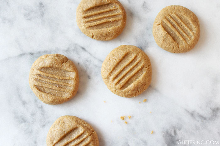 Say hello to the very best peanut butter cookies around! Make and bake a batch in about ten minutes, and revel in the most delicious, flourless peanut butter cookies ever. Click through for the recipe. #peanutbuttercookies #cookies #peanutbuttercookiesrecipe #flourlesscookies #flourlesspeanutbuttercookies #threeingredientpeanutbuttercookies #easycookies | glitterinc.com | @glitterinc