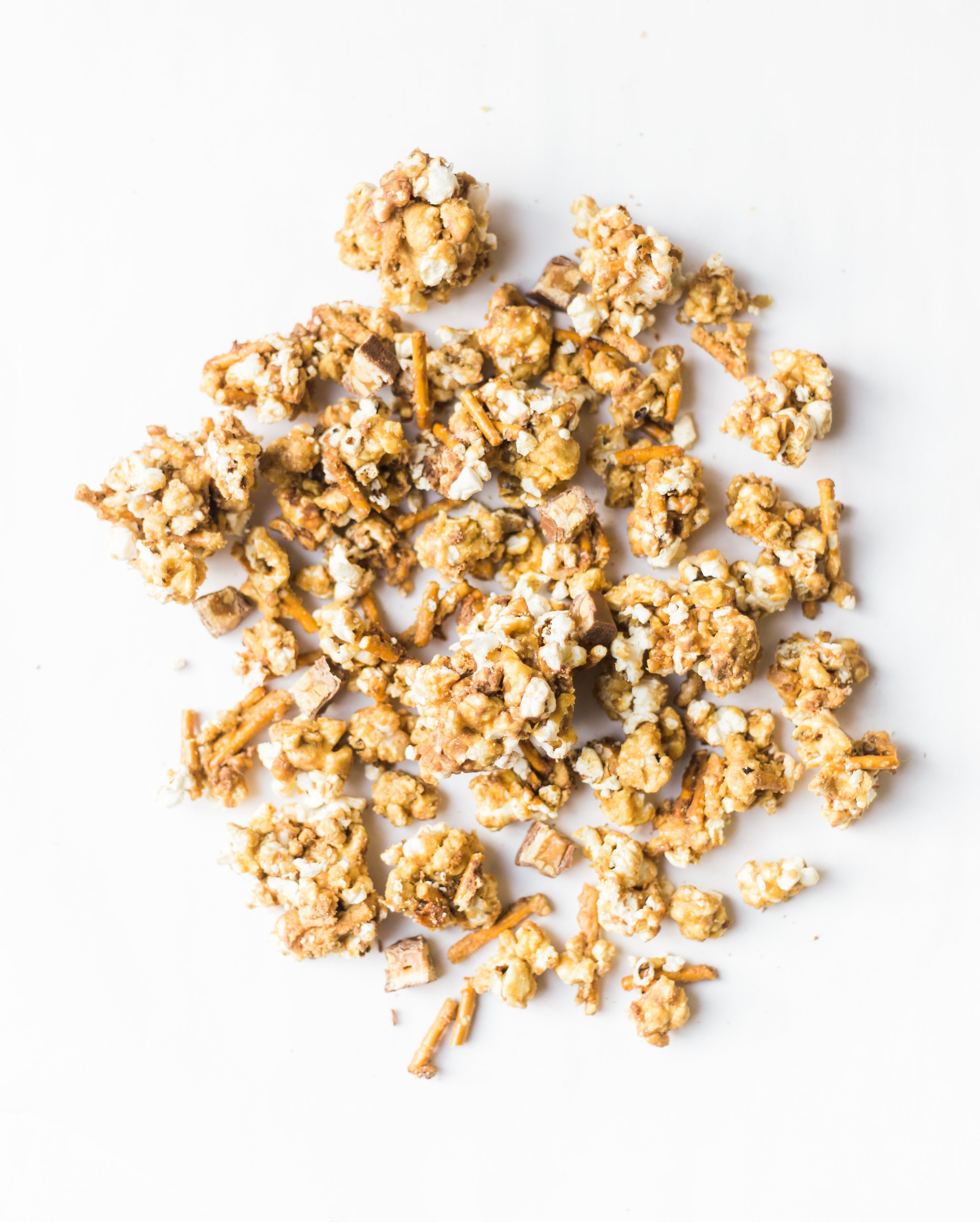 How to make your new favorite game day salted pretzel Snickers vanilla caramel corn. This sweet and salty mixture is just TOO GOOD. Click through for the recipe. | glitterinc.com | @glitterinc