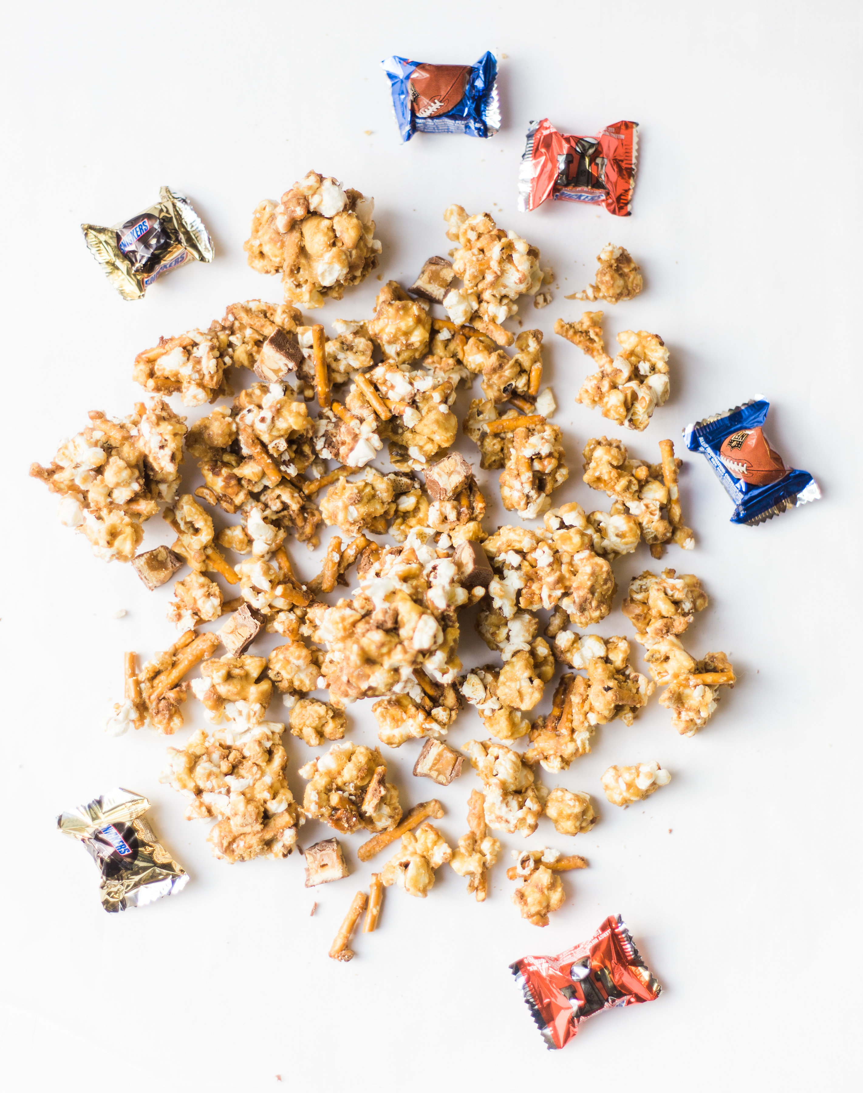 How to make your new favorite game day salted pretzel Snickers vanilla caramel corn. This sweet and salty mixture is just TOO GOOD. Click through for the recipe. | glitterinc.com | @glitterinc