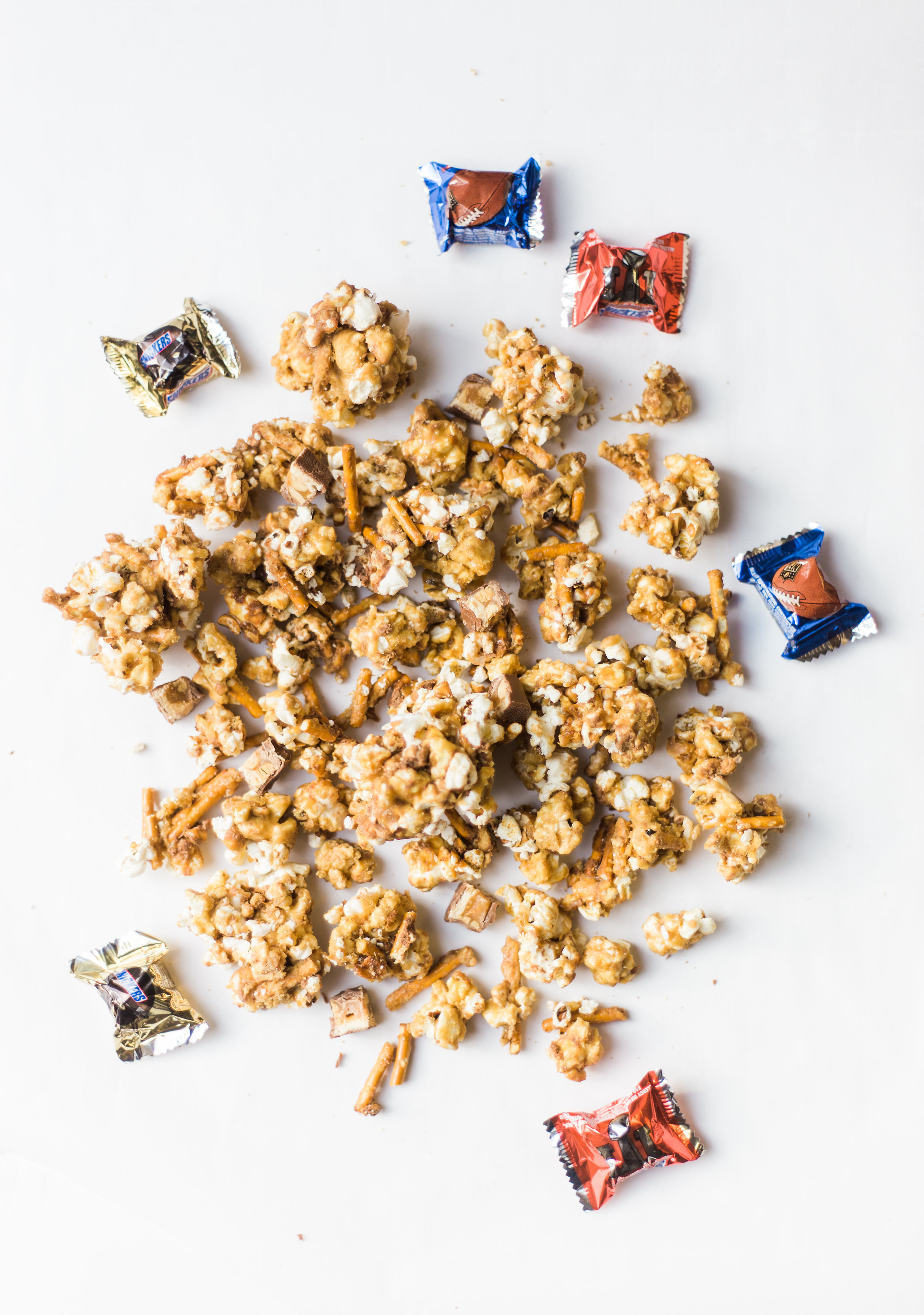 How to make your new favorite game day salted pretzel Snickers vanilla caramel corn. This sweet and salty mixture is just TOO GOOD. Click through for the recipe. | glitterinc.com | @glitterinc