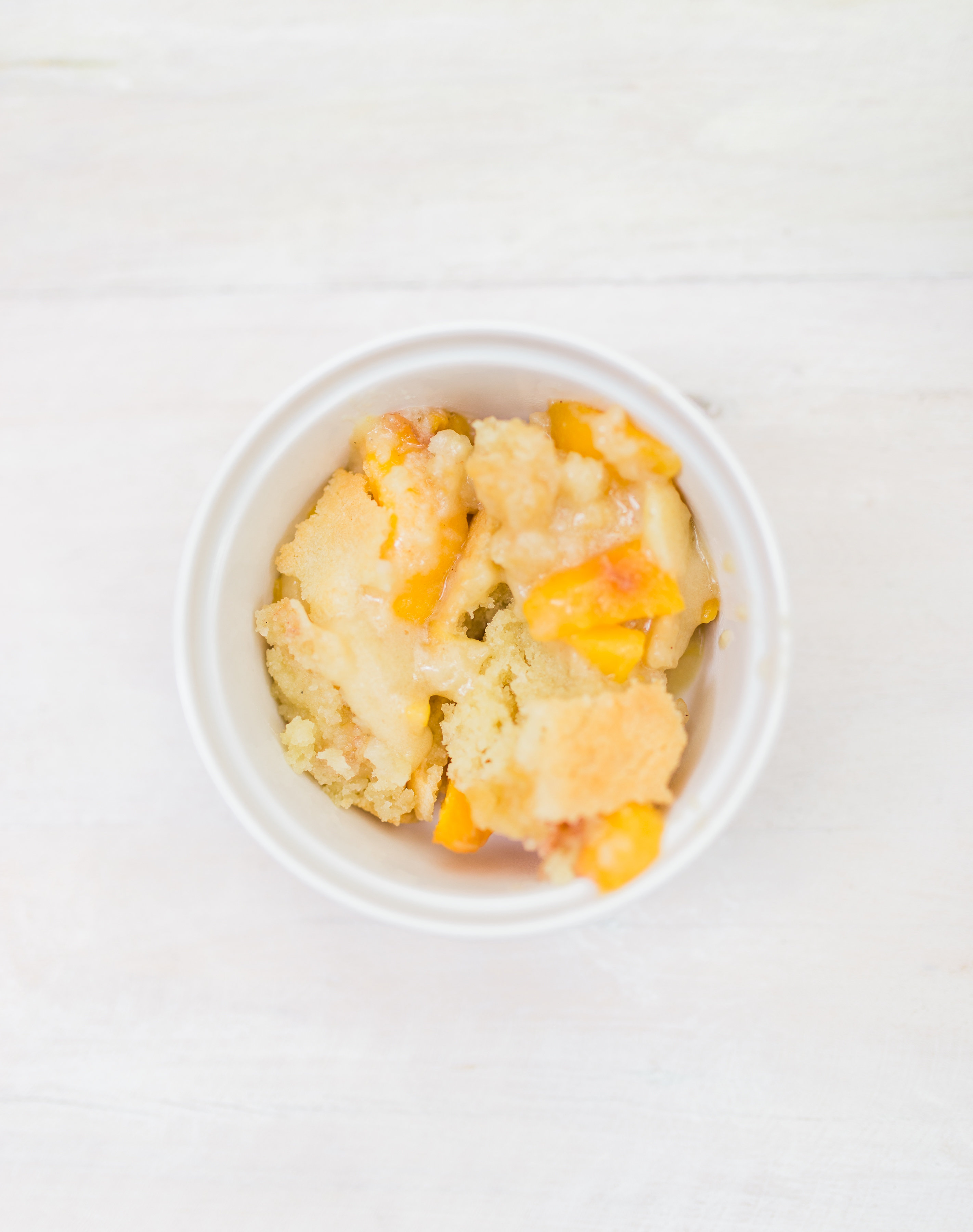 Foodie blogger Lexi of Glitter, Inc. shares a recipe for classic peach cobbler. Caramelized peaches are topped with a sugar-cookie-like doughy crust. YUM. | glitterinc.com | @glitterinc