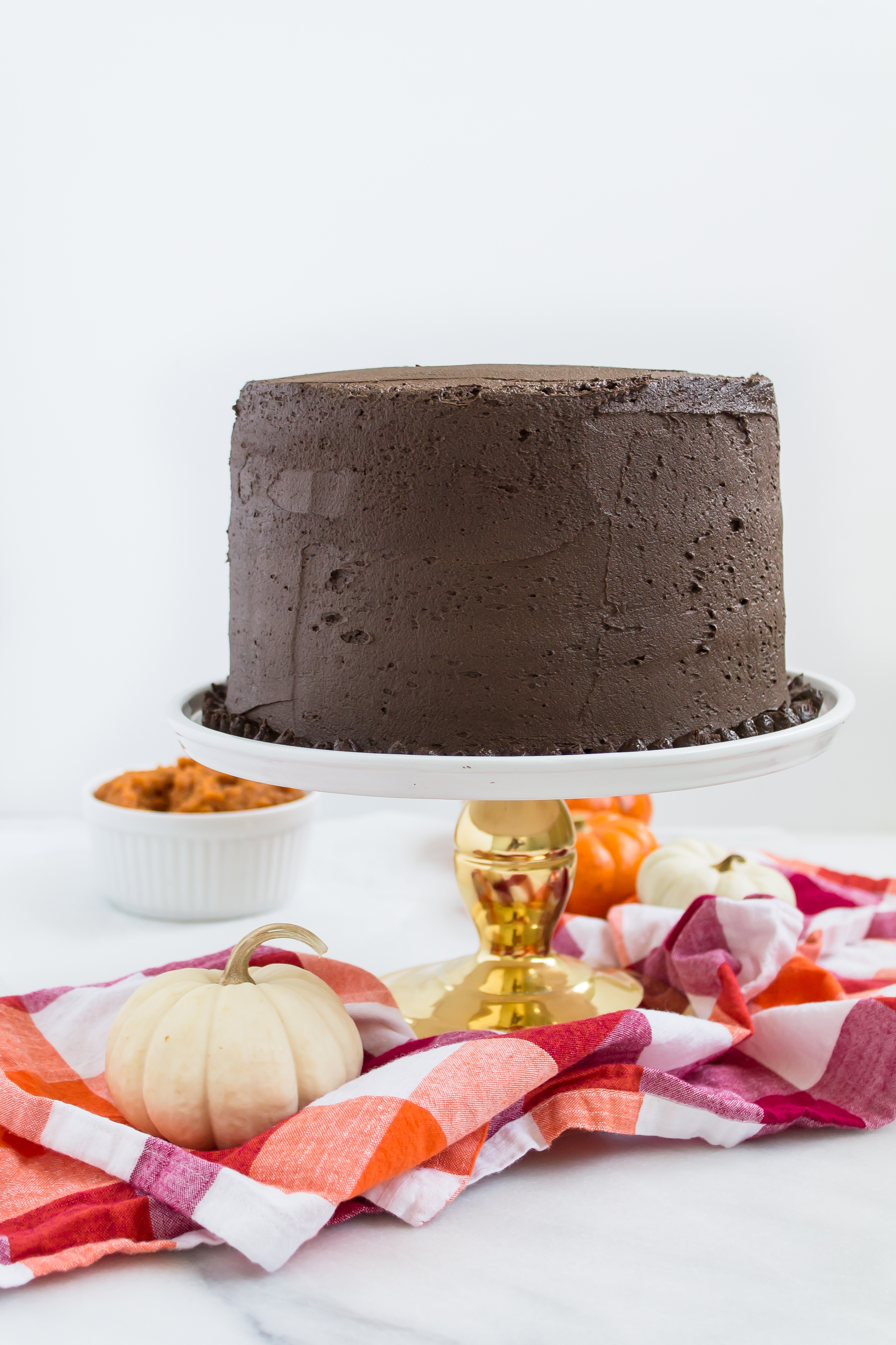 This incredibly moist spiced pumpkin cake topped with a rich and fluffy chocolate frosting is perfect for fall. Click through for the recipe. | glitterinc.com | @glitterinc - Pumpkin Cake Recipe with Fluffy Chocolate Frosting by North Carolina foodie blogger Glitter, Inc.