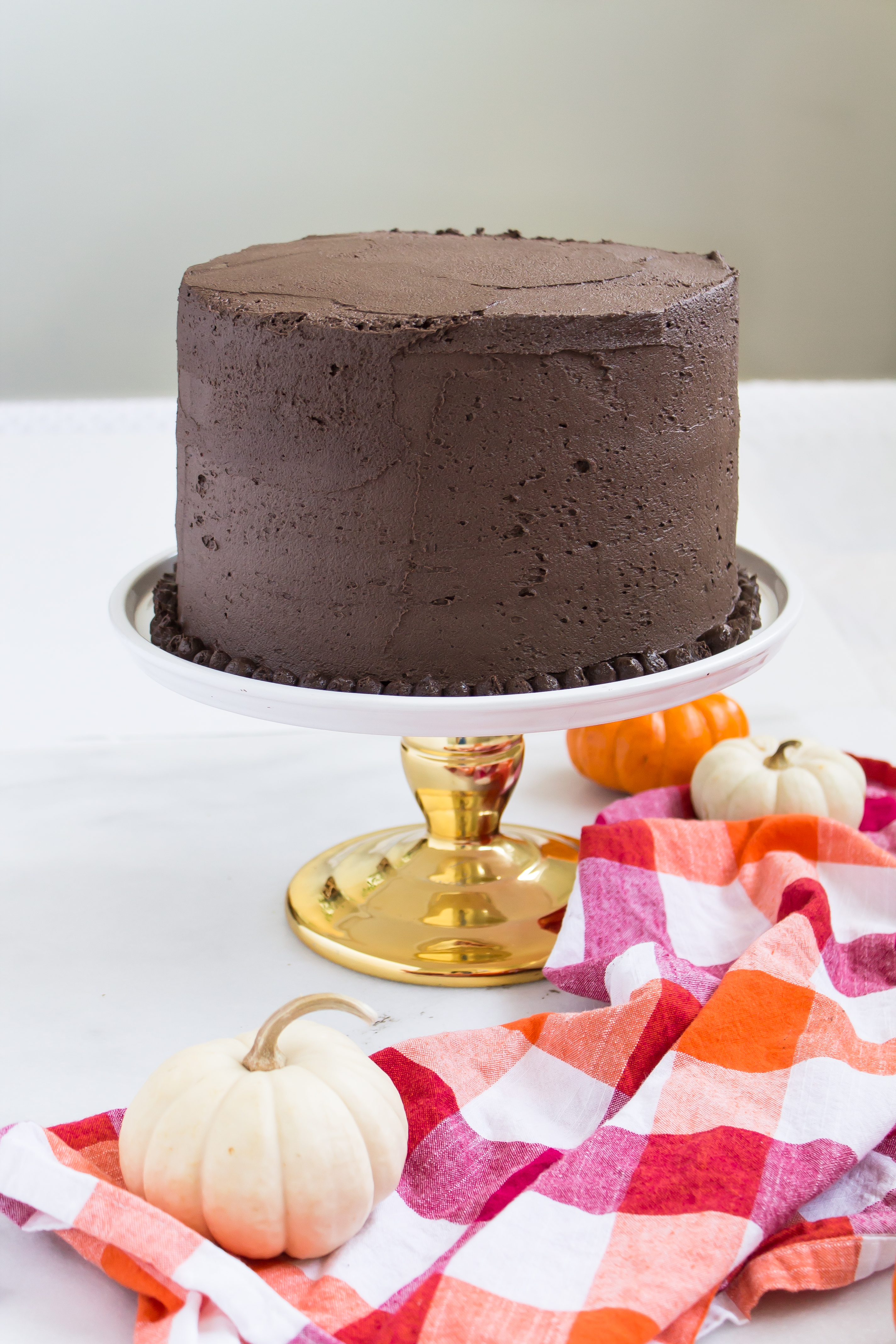 This incredibly moist spiced pumpkin cake topped with a rich and fluffy chocolate frosting is perfect for fall. Click through for the recipe. | glitterinc.com | @glitterinc