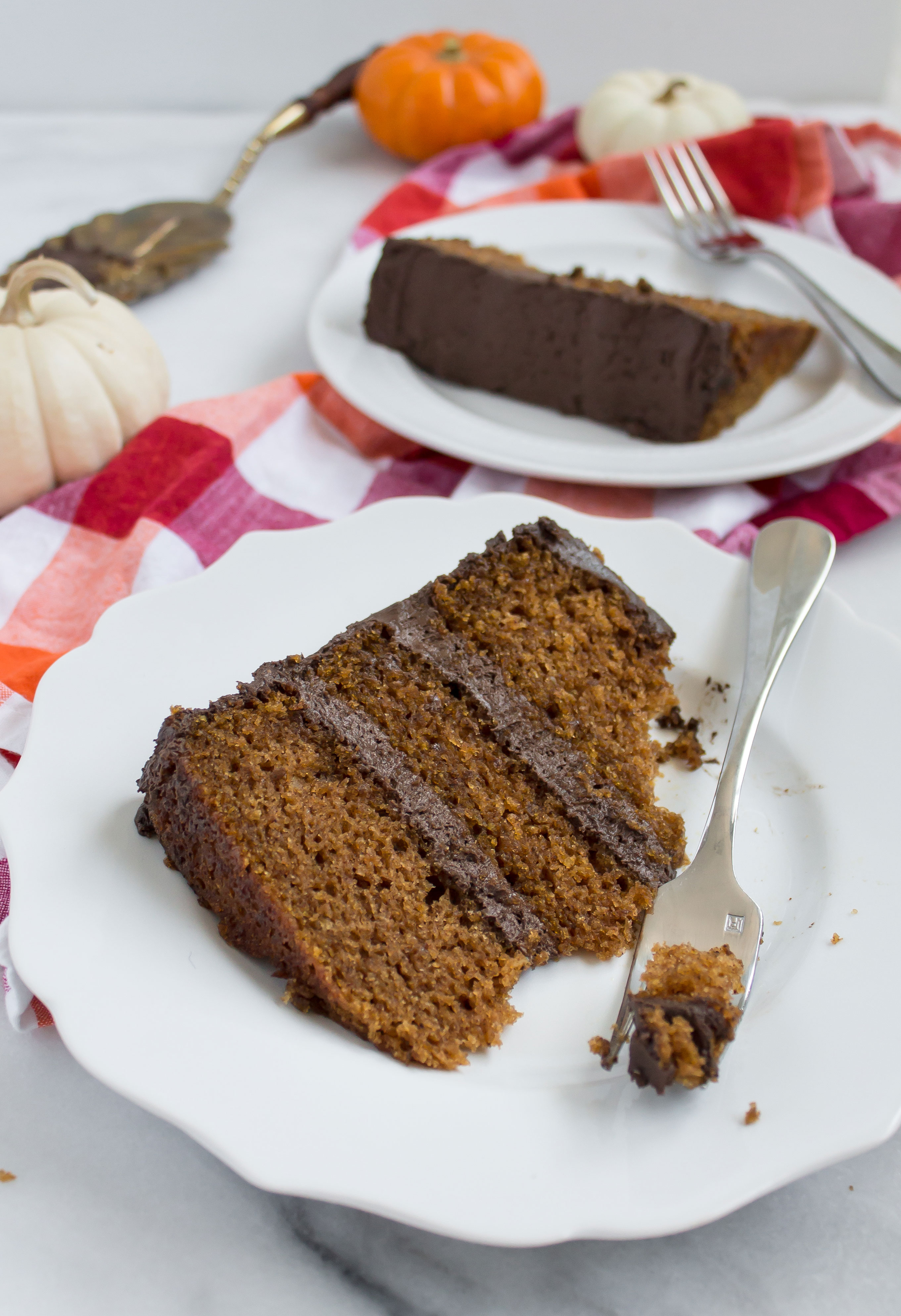 This incredibly moist spiced pumpkin cake topped with a rich and fluffy chocolate frosting is perfect for fall. Click through for the recipe. | glitterinc.com | @glitterinc - Pumpkin Cake Recipe with Fluffy Chocolate Frosting by North Carolina foodie blogger Glitter, Inc.