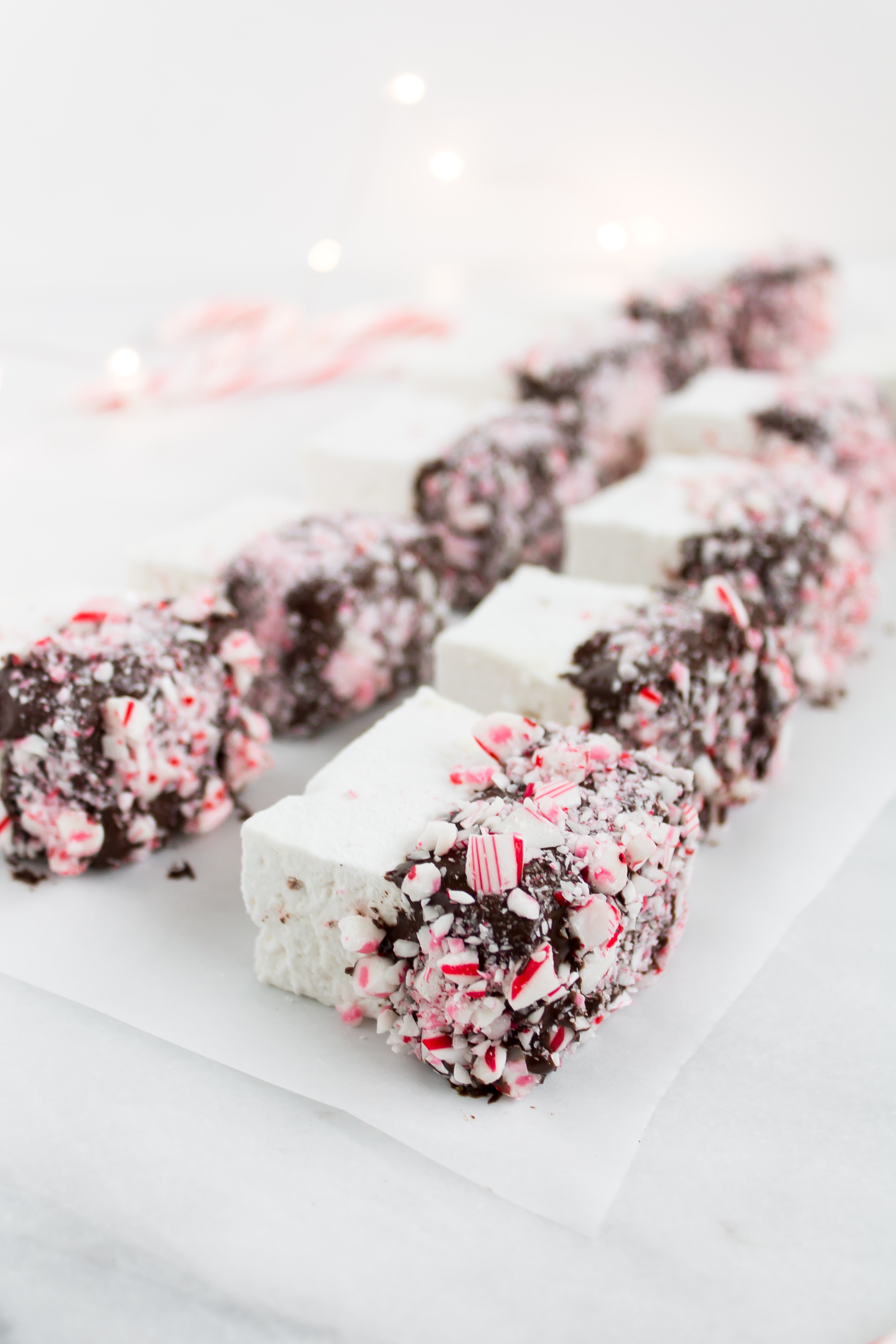 There's nothing like homemade marshmallows. Dipping those fluffy marshmallows in chocolate and crushed peppermint for the holidays is just the icing on the cake ... errr, marshmallow. Click through for the recipe. | glitterinc.com | @glitterinc - Homemade Chocolate Covered Marshmallows with Crushed Peppermint by North Carolina foodie blogger Glitter, Inc.