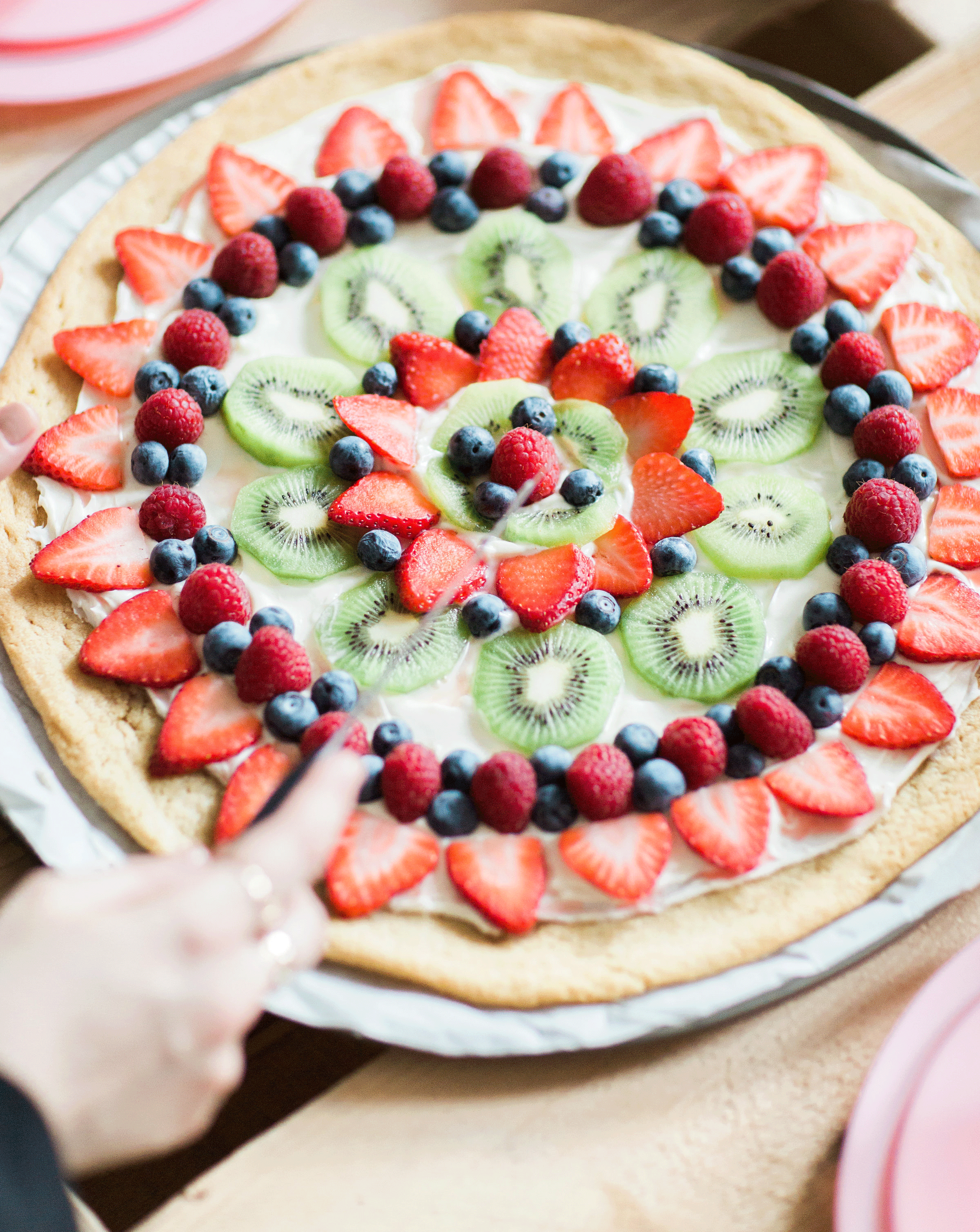 Learn how to make your own amazing cookie fruit pizza! This super simple and surprisingly dairy-free sugar cookie fruit pizza Recipe is not only super yummy, but the end result will seriously impress your party guests. | glitterinc.com | @glitterinc