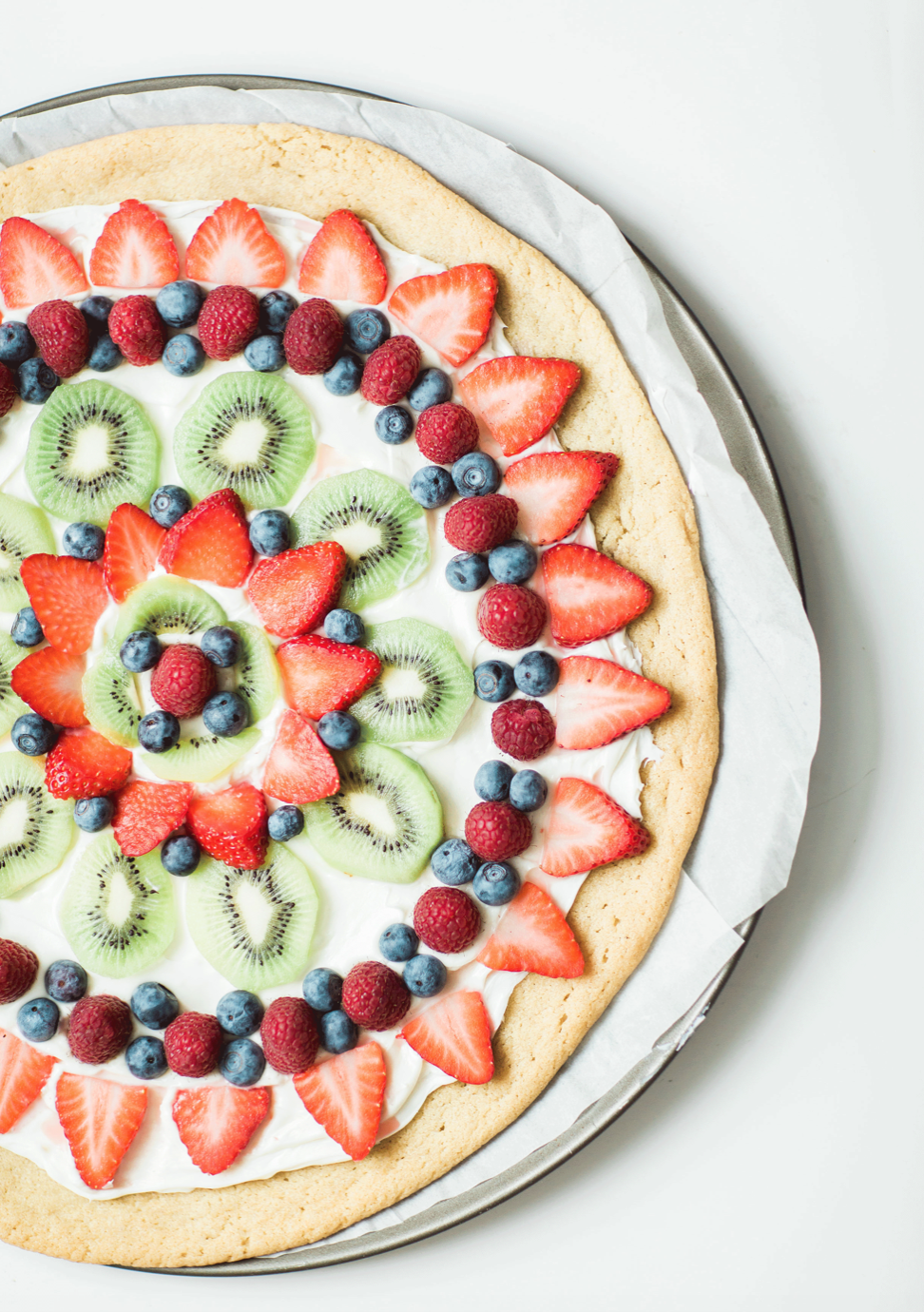 Learn how to make your own amazing cookie fruit pizza! This super simple and surprisingly dairy-free sugar cookie fruit pizza Recipe is not only super yummy, but the end result will seriously impress your party guests. | glitterinc.com | @glitterinc