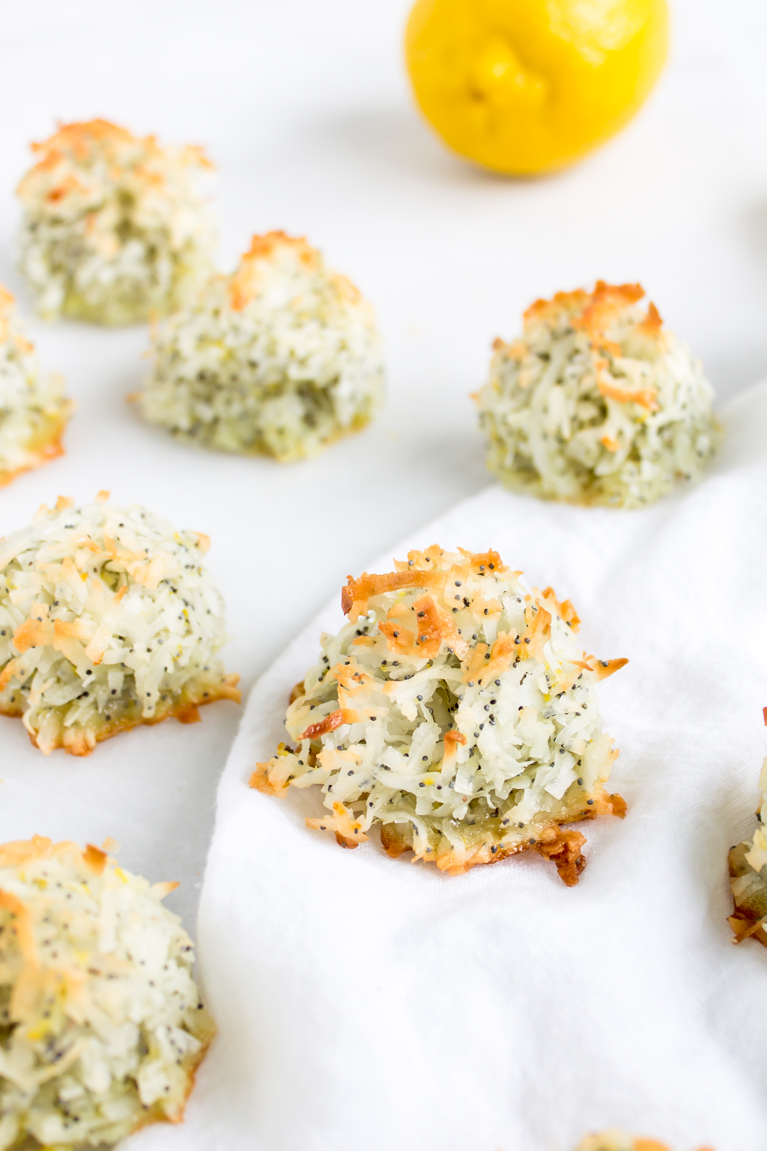 Coconut macaroons have the perfect balance of textures - crunchy on the outside, but moist and chewy on the inside. This lemon poppy seed version of the classic flourless cookie is packed with fresh, zesty citrus flavor for a wonderful spring or Passover treat! Click through for the recipe. | glitterinc.com | @glitterinc - Lemon Poppyseed Coconut Macaroons Recipe by popular North Carolina foodie blog Glitter, Inc.