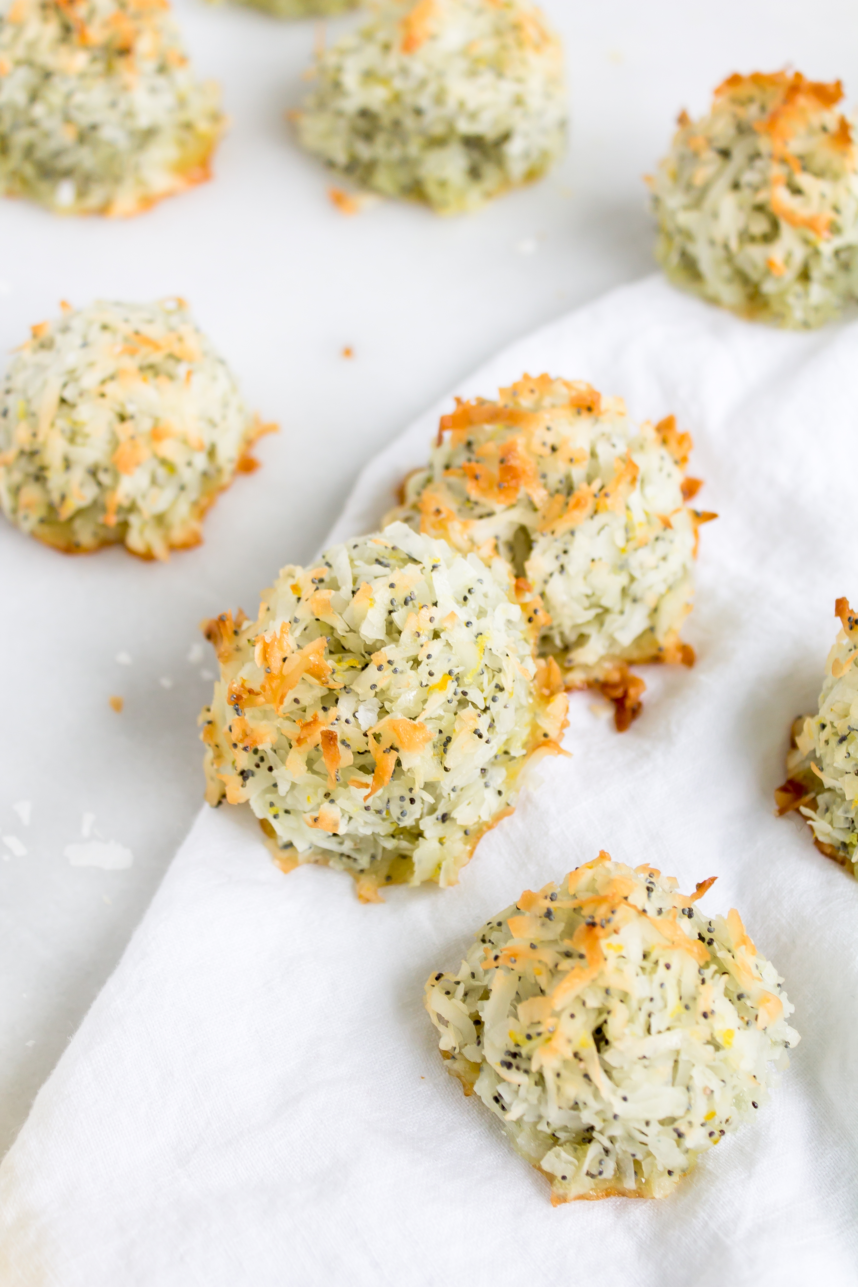 Coconut macaroons have the perfect balance of textures - crunchy on the outside, but moist and chewy on the inside. This lemon poppy seed version of the classic flourless cookie is packed with fresh, zesty citrus flavor for a wonderful spring or Passover treat! Click through for the recipe. | glitterinc.com | @glitterinc - Lemon Poppyseed Coconut Macaroons Recipe by popular North Carolina foodie blog Glitter, Inc.