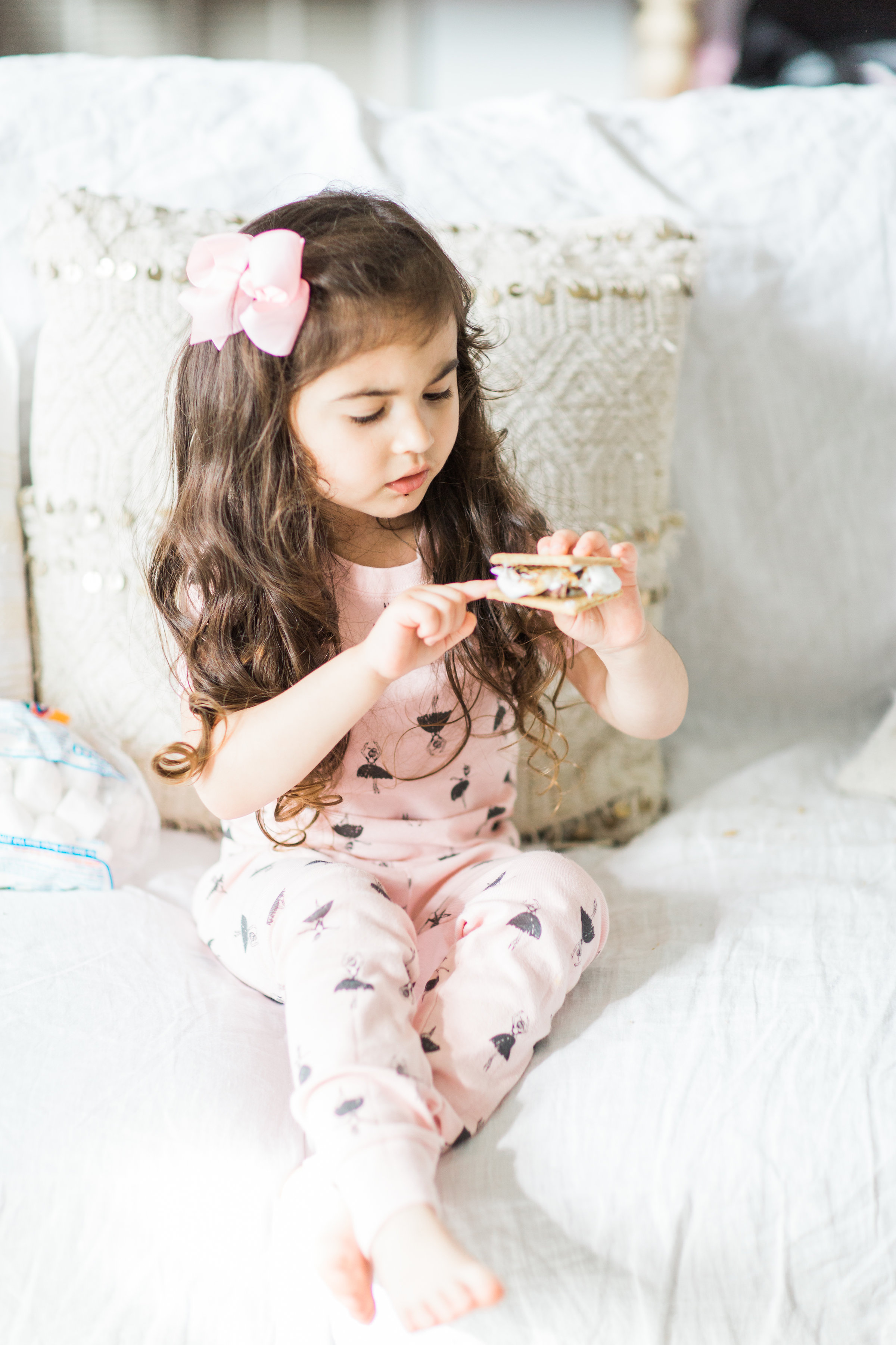 I'm sharing a big 'ol dose of cuteness; a.k.a., the behind-the-scenes of the girls trying s'mores for the first time (and caught on camera) from our family movie night! #smores #matchingpajamas #movienight #familyfun #smoresparty | glitterinc.com | @glitterinc