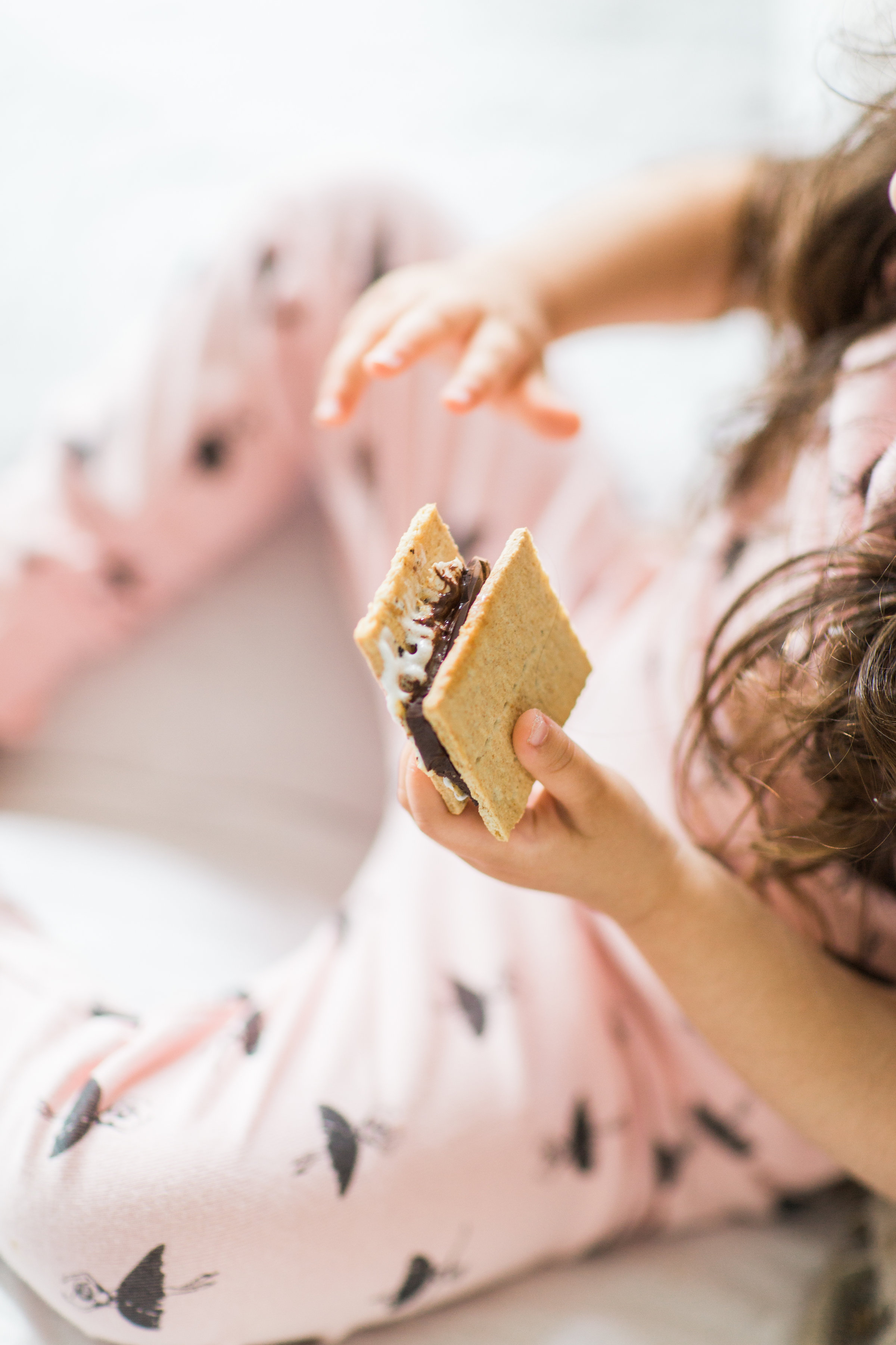 I'm sharing a big 'ol dose of cuteness; a.k.a., the behind-the-scenes of the girls trying s'mores for the first time (and caught on camera) from our family movie night! #smores #matchingpajamas #movienight #familyfun #smoresparty | glitterinc.com | @glitterinc