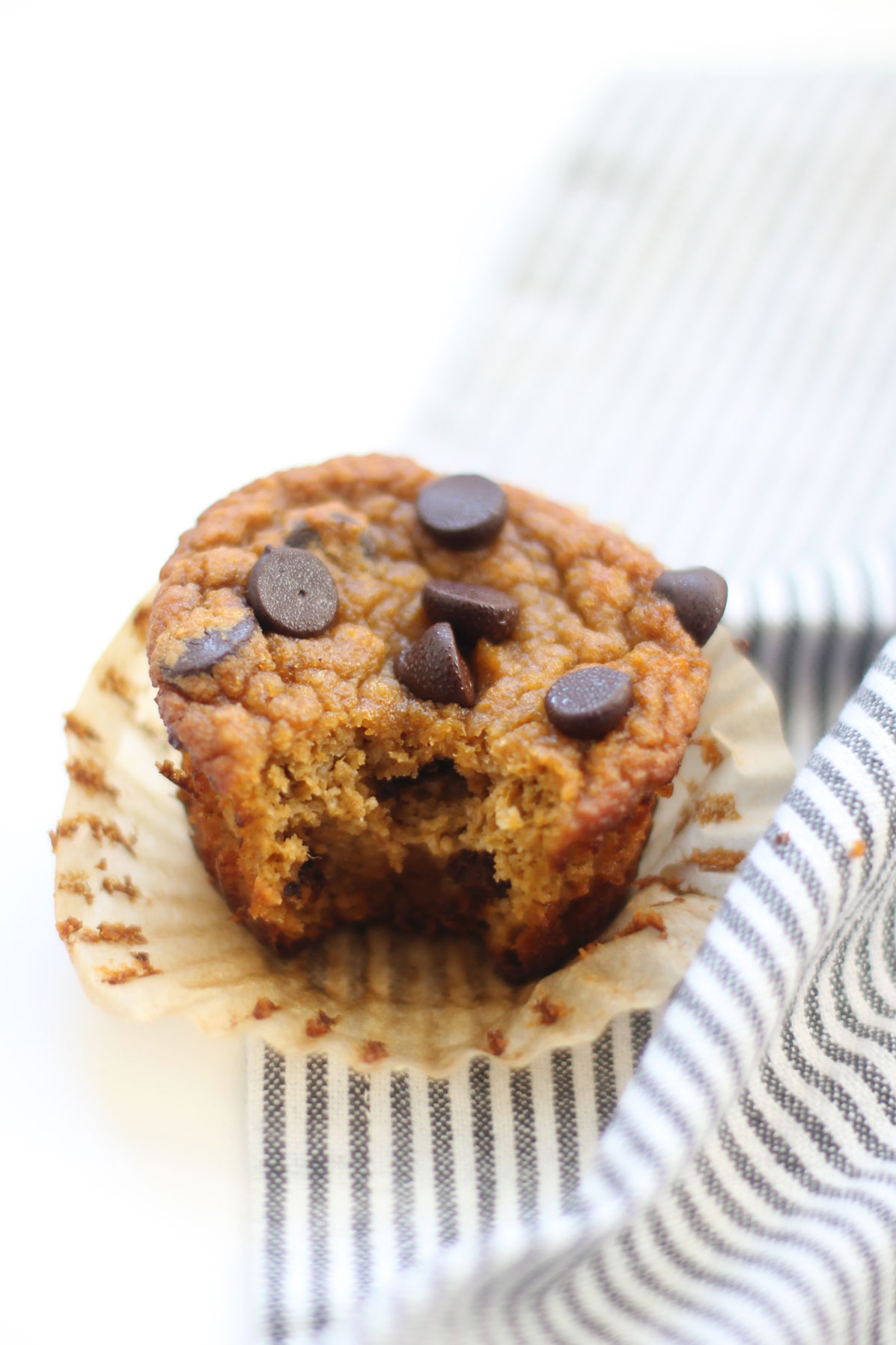 We've created the perfect healthy muffin! Fluffy roasted sweet potato muffins made with almond flour (i.e., gluten-free), greek yogurt (or coconut yogurt to keep it dairy-free!), plus a handful of chocolate chips; you'll be amazed at what a healthy vegan and paleo on-the-go breakfast or snack can taste like. Click through for the recipe. | glitterinc.com | @glitterinc #muffins #healthybreakfast #healthymuffins