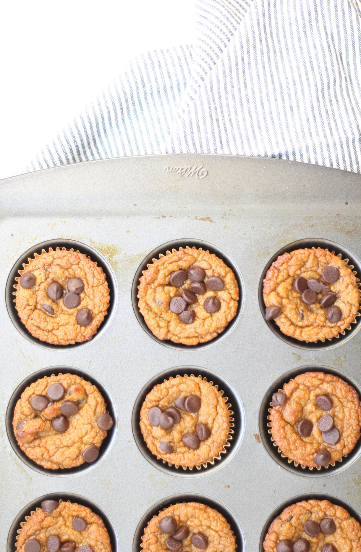 We've created the perfect healthy muffin! Fluffy roasted sweet potato muffins made with almond flour (i.e., gluten-free), greek yogurt (or coconut yogurt to keep it dairy-free!), plus a handful of chocolate chips; you'll be amazed at what a healthy vegan and paleo on-the-go breakfast or snack can taste like. Click through for the recipe. | glitterinc.com | @glitterinc #muffins #healthybreakfast #healthymuffins