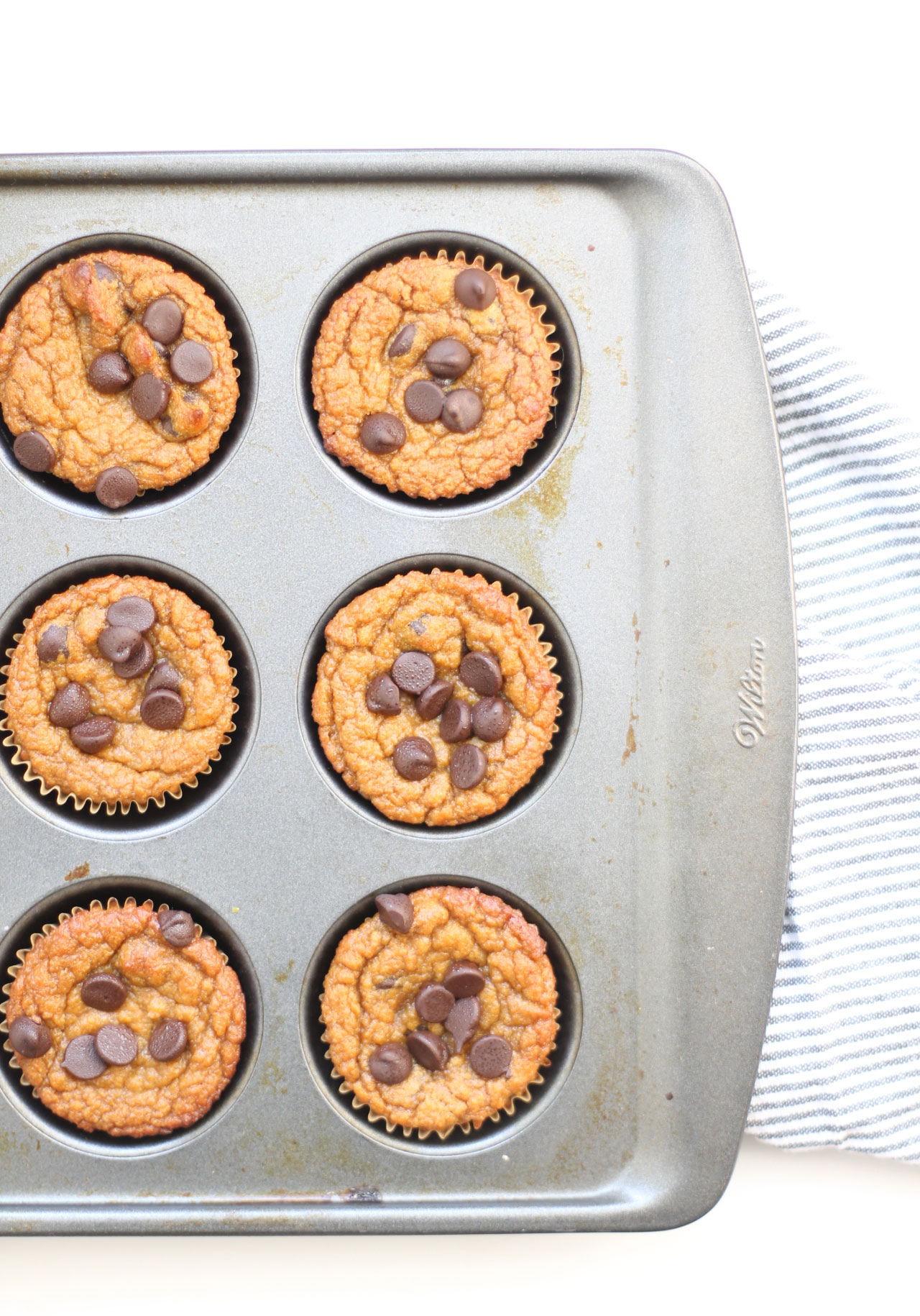 We've created the perfect healthy muffin! Fluffy roasted sweet potato muffins made with almond flour (i.e., gluten-free), greek yogurt (or coconut yogurt to keep it dairy-free!), plus a handful of chocolate chips; you'll be amazed at what a healthy vegan and paleo on-the-go breakfast or snack can taste like. Click through for the recipe. | glitterinc.com | @glitterinc #muffins #healthybreakfast #healthymuffins