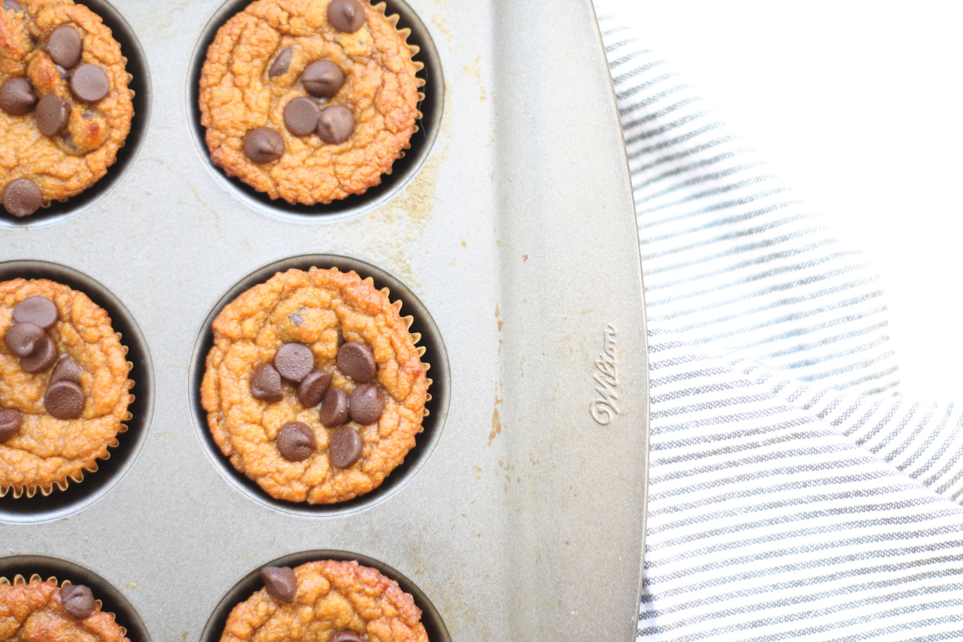 We've created the perfect healthy muffin! Fluffy roasted sweet potato muffins made with almond flour (i.e., gluten-free), greek yogurt (or coconut yogurt to keep it dairy-free!), plus a handful of chocolate chips; you'll be amazed at what a healthy vegan and paleo on-the-go breakfast or snack can taste like. Click through for the recipe. | glitterinc.com | @glitterinc #muffins #healthybreakfast #healthymuffins