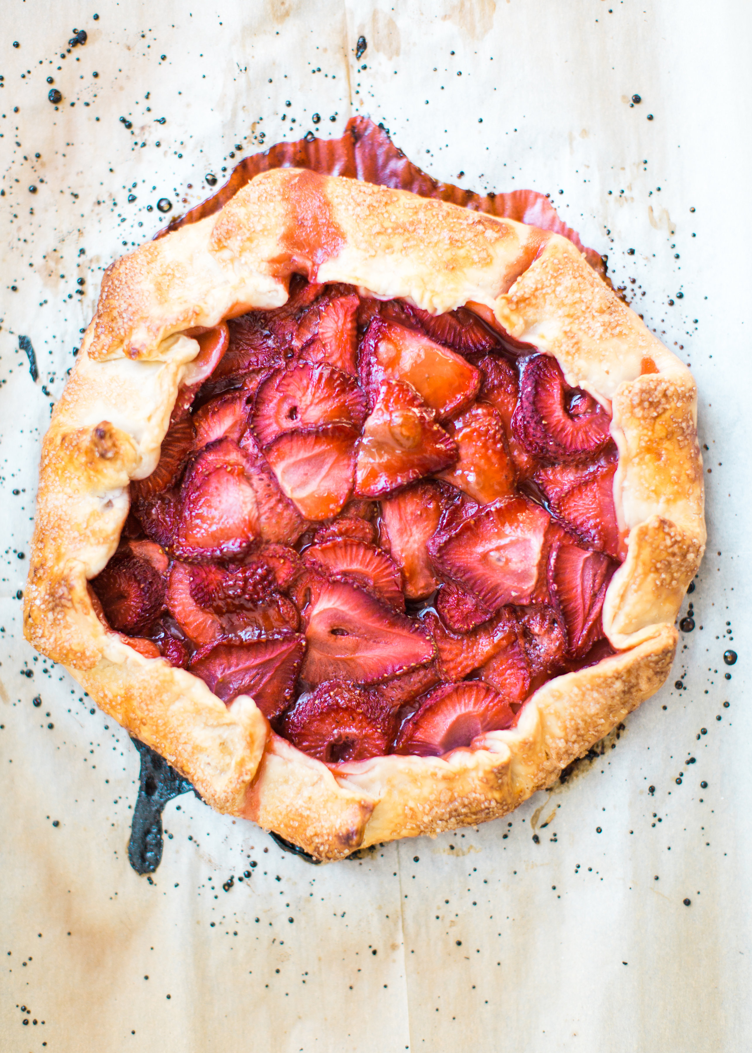 Flaky pie dough, a sweet jam and fresh strawberry filling, and a sprinkling of turbinado sugar on the crust, makes this simple strawberry galette or crostata, a.k.a., pie made easy using store-bought crust, the stuff of dreams. Click through for the recipe. #pie #strawberrypie #strawberrygalette #strawberrycrostata #crostata #galette #simplesummerdessert #summerdessert #springdessert #simpledessert #easydessert #easypie #simplepie | glitterinc.com | @glitterinc