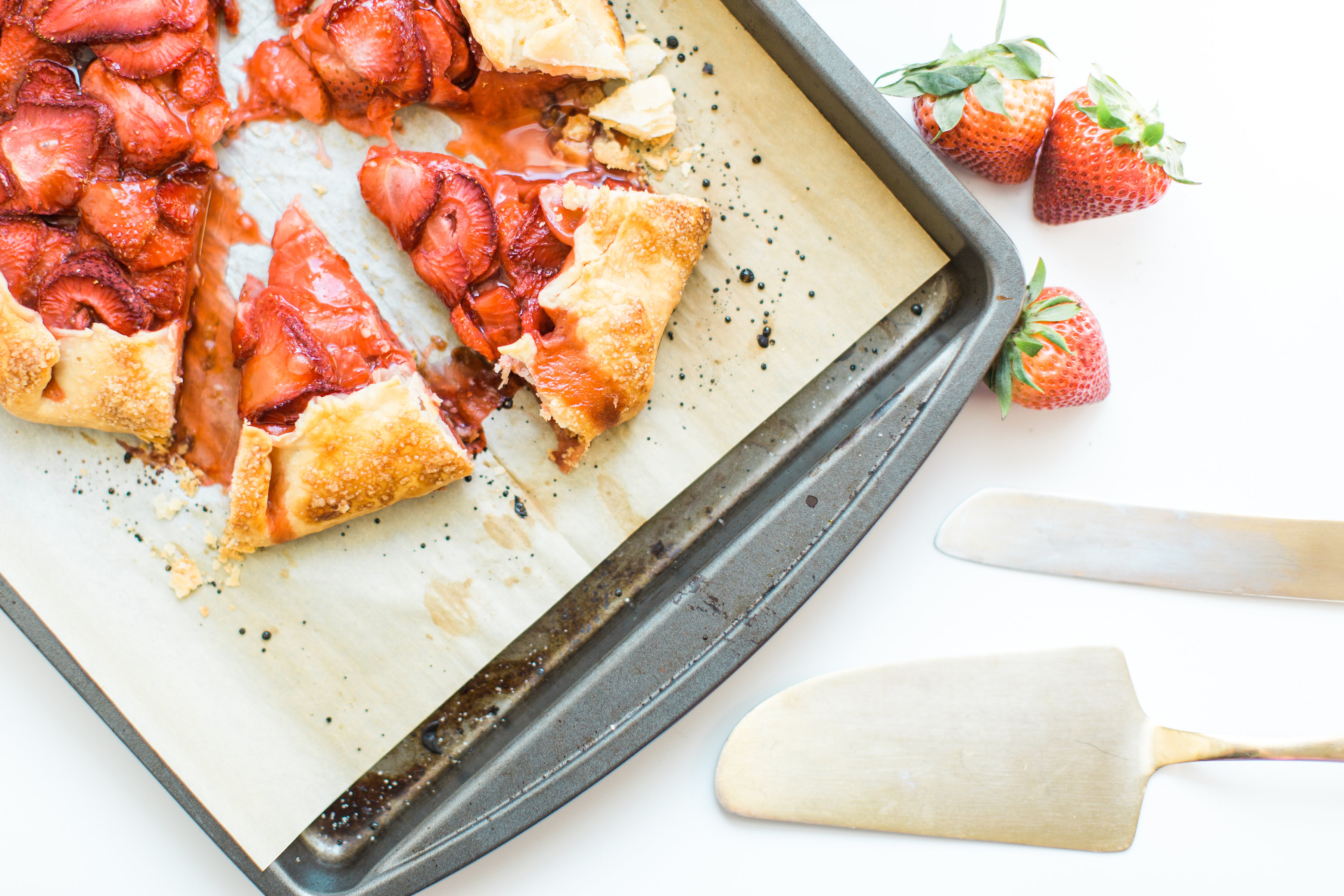 Flaky pie dough, a sweet jam and fresh strawberry filling, and a sprinkling of turbinado sugar on the crust, makes this simple strawberry galette or crostata, a.k.a., pie made easy using store-bought crust, the stuff of dreams. Click through for the recipe. #pie #strawberrypie #strawberrygalette #strawberrycrostata #crostata #galette #simplesummerdessert #summerdessert #springdessert #simpledessert #easydessert #easypie #simplepie | glitterinc.com | @glitterinc