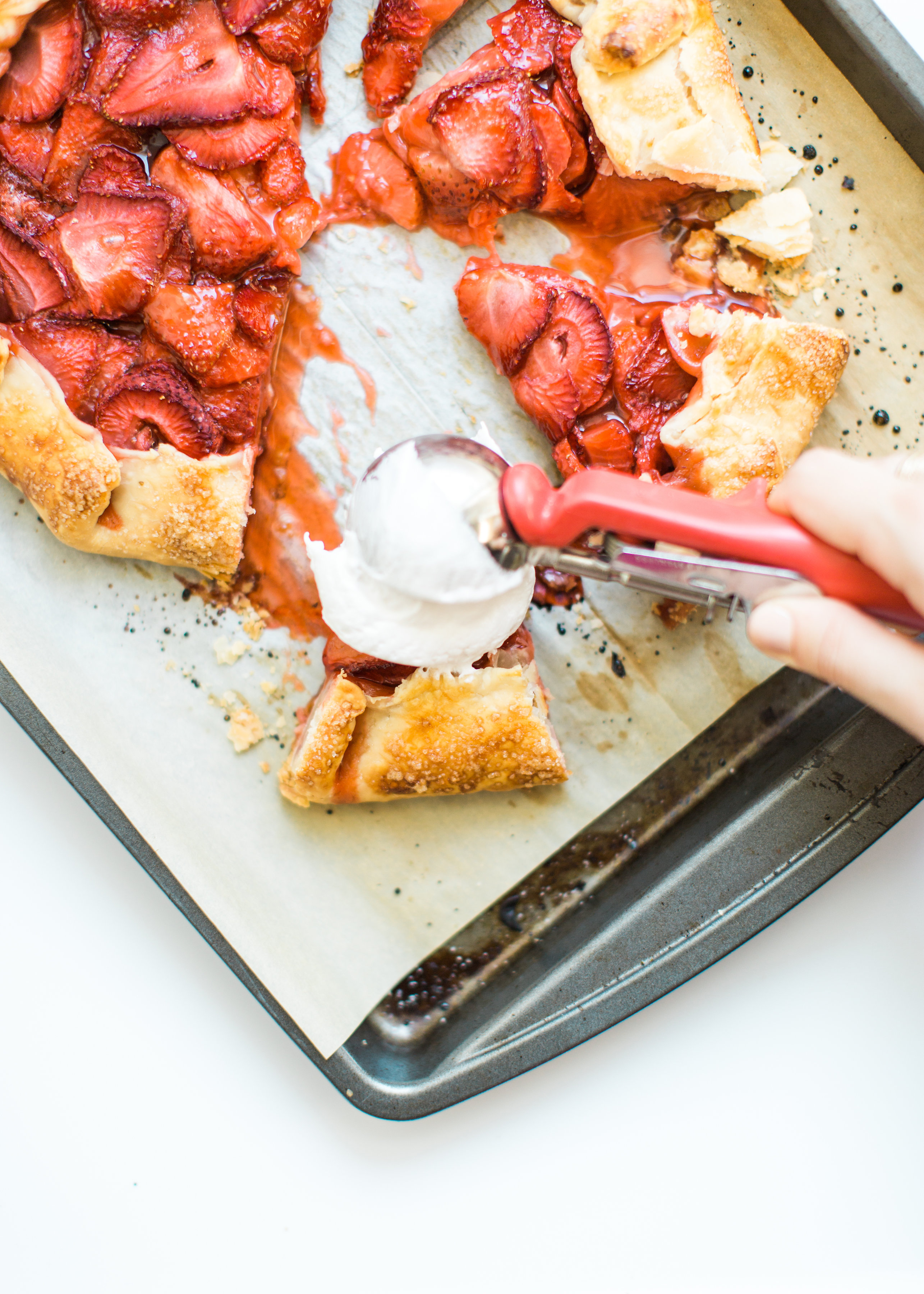 Flaky pie dough, a sweet jam and fresh strawberry filling, and a sprinkling of turbinado sugar on the crust, makes this simple strawberry galette or crostata, a.k.a., pie made easy using store-bought crust, the stuff of dreams. Click through for the recipe. #pie #strawberrypie #strawberrygalette #strawberrycrostata #crostata #galette #simplesummerdessert #summerdessert #springdessert #simpledessert #easydessert #easypie #simplepie | glitterinc.com | @glitterinc