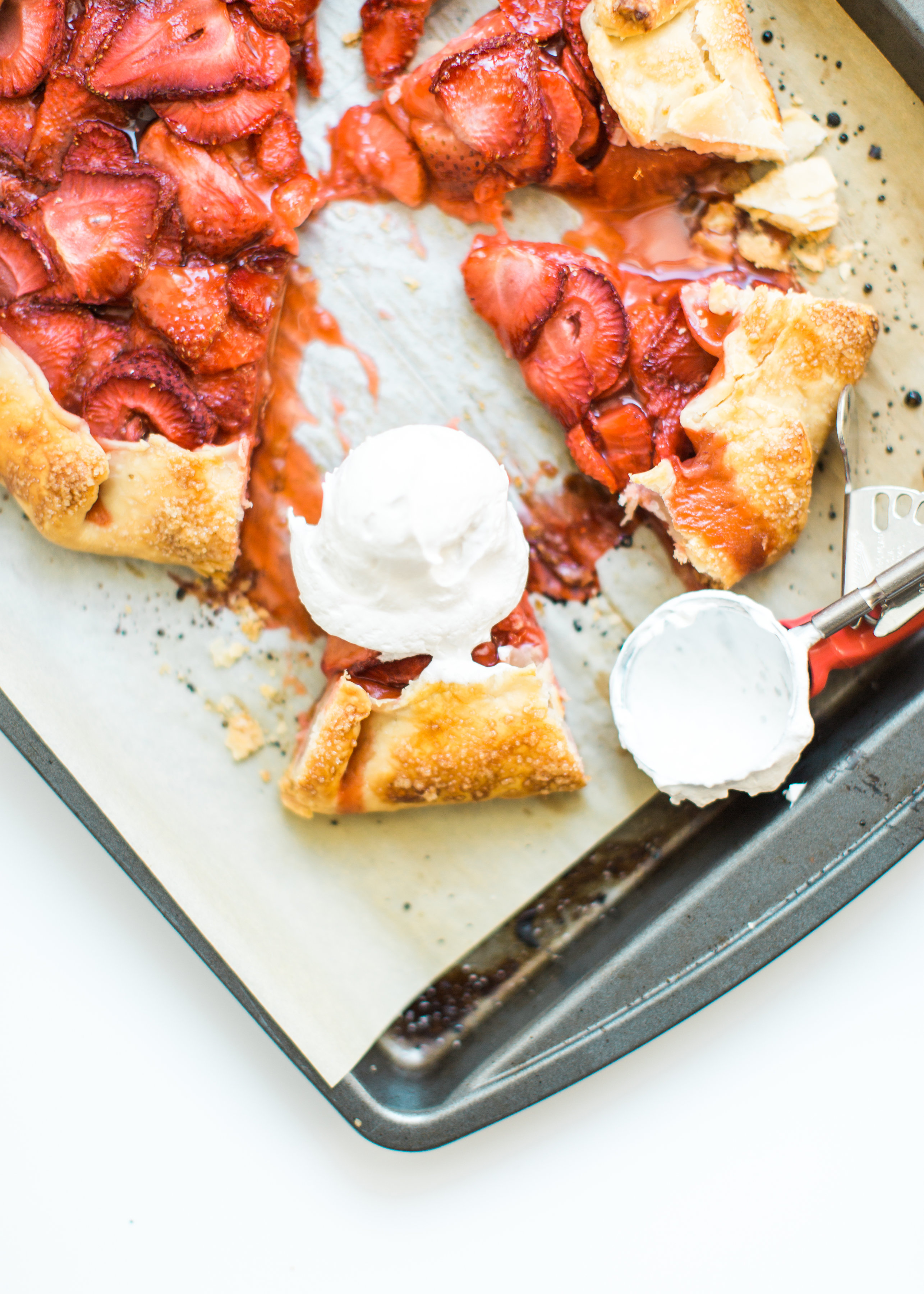 Flaky pie dough, a sweet jam and fresh strawberry filling, and a sprinkling of turbinado sugar on the crust, makes this simple strawberry galette or crostata, a.k.a., pie made easy using store-bought crust, the stuff of dreams. Click through for the recipe. #pie #strawberrypie #strawberrygalette #strawberrycrostata #crostata #galette #simplesummerdessert #summerdessert #springdessert #simpledessert #easydessert #easypie #simplepie | glitterinc.com | @glitterinc