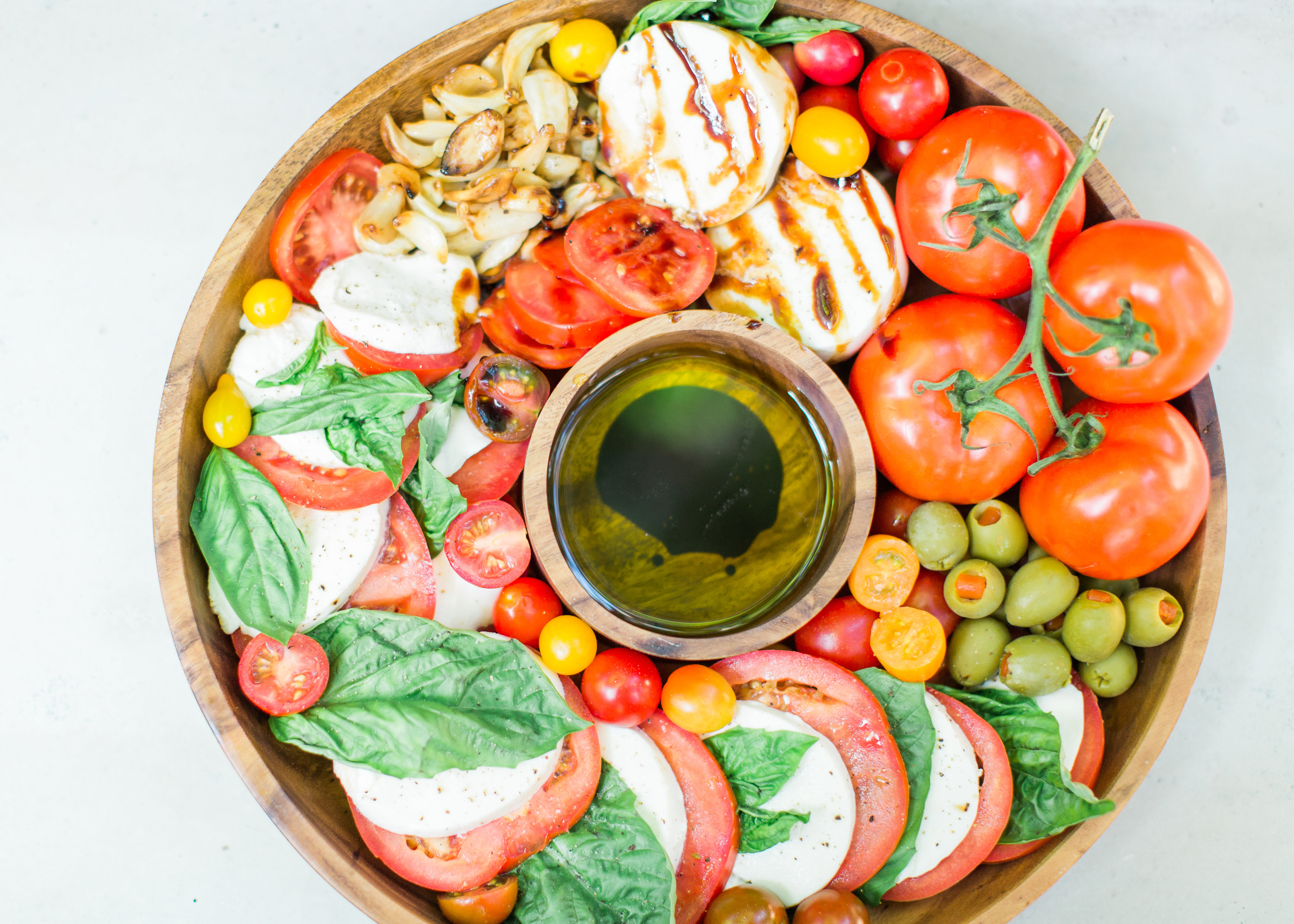 Tomatoes, fresh mozzarella, and basil drizzled with balsamic vinegar, or a sweet balsamic reduction, and olive oil; a caprese salad platter is so easy to make, looks beautiful and impressive (hello, wow factor!), and the magical combination of flavors is totally delicious. Click through for the recipe. #caprese #capresesalad #capresesaladplatter #appetizer #salad #partyfood #recipe #capreserecipe | glitterinc.com | @glitterinc