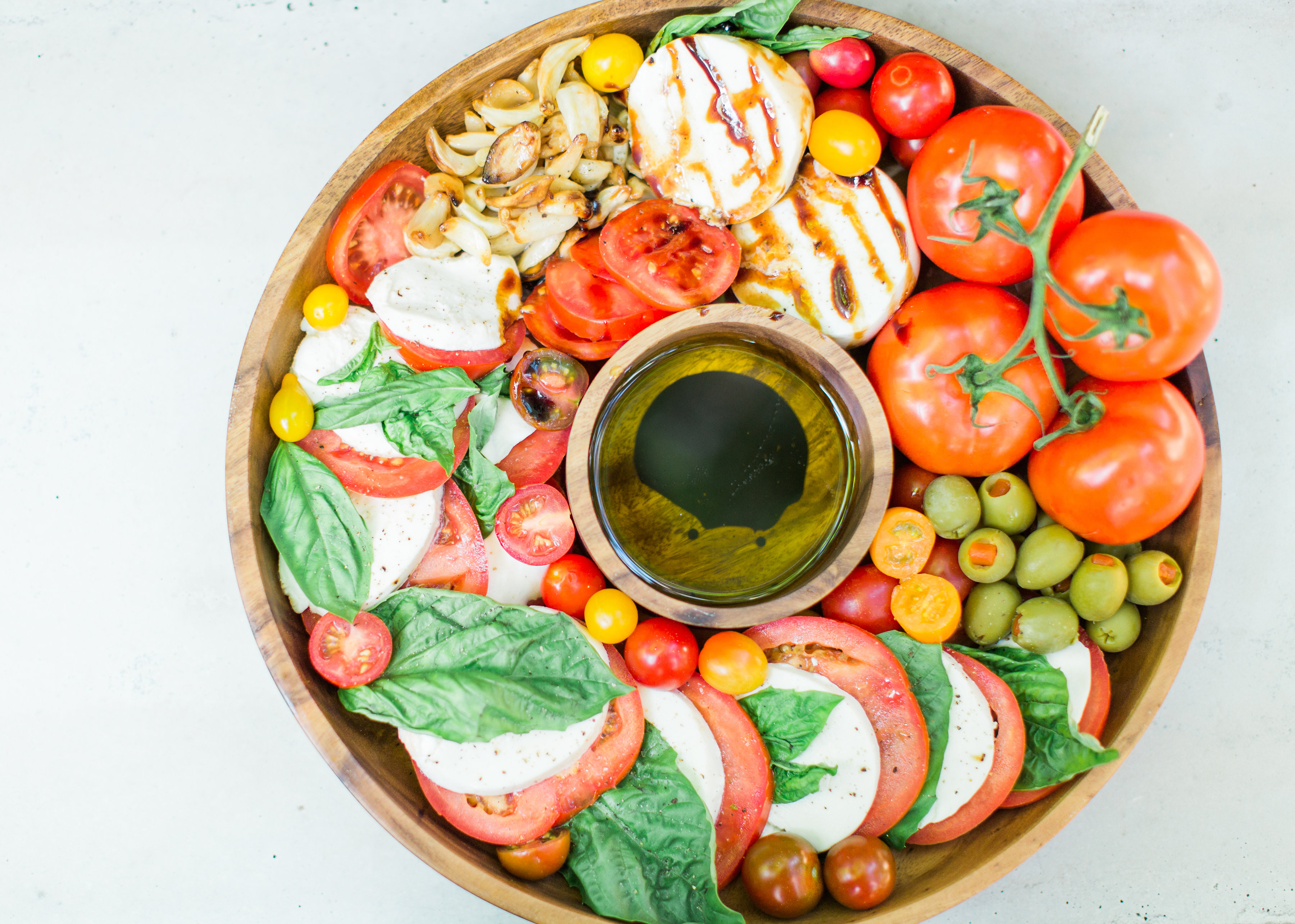 Tomatoes, fresh mozzarella, and basil drizzled with balsamic vinegar, or a sweet balsamic reduction, and olive oil; a caprese salad platter is so easy to make, looks beautiful and impressive (hello, wow factor!), and the magical combination of flavors is totally delicious. Click through for the recipe. #caprese #capresesalad #capresesaladplatter #appetizer #salad #partyfood #recipe #capreserecipe | glitterinc.com | @glitterinc