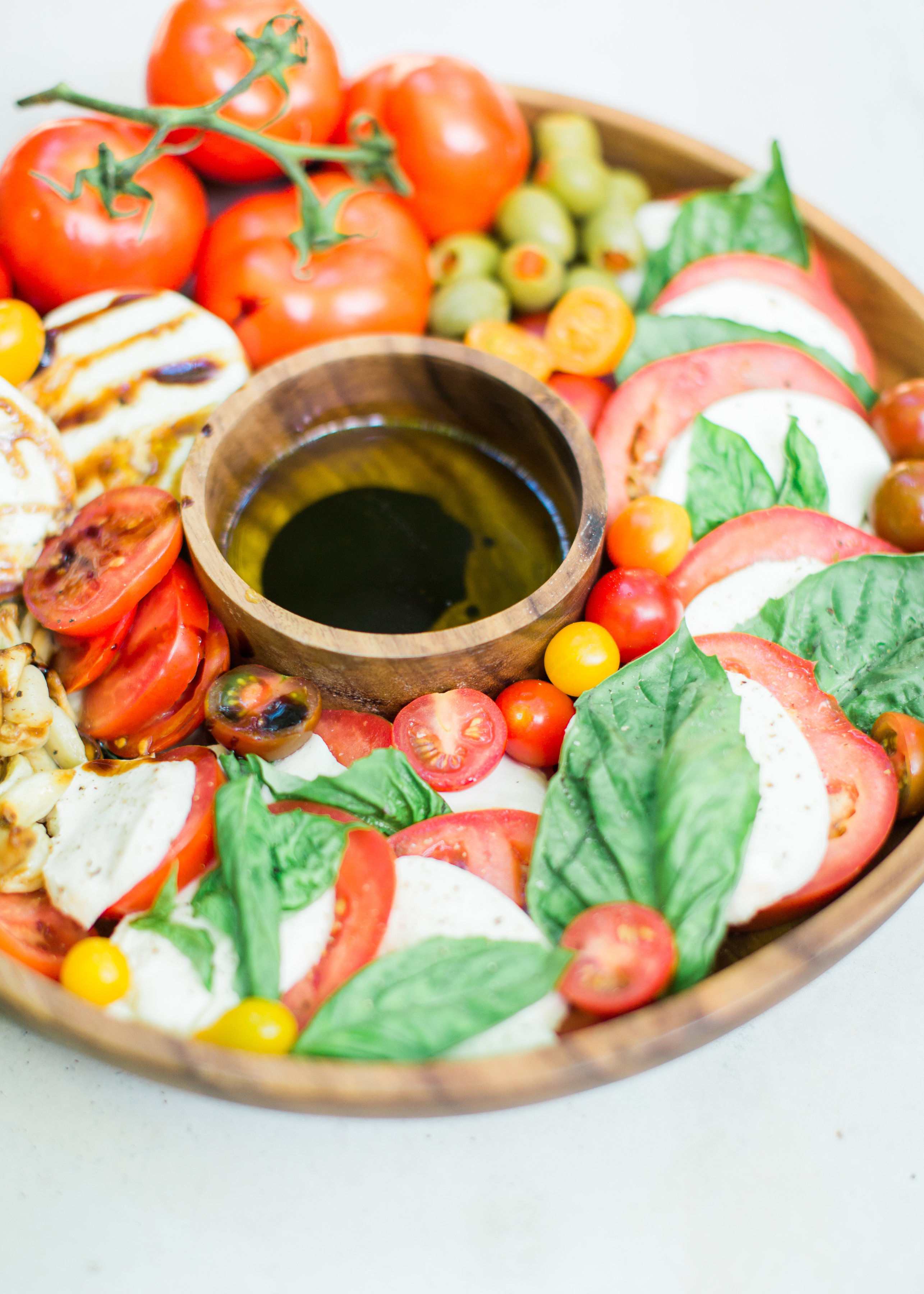 Tomatoes, fresh mozzarella, and basil drizzled with balsamic vinegar, or a sweet balsamic reduction, and olive oil; a caprese salad platter is so easy to make, looks beautiful and impressive (hello, wow factor!), and the magical combination of flavors is totally delicious. Click through for the recipe. #caprese #capresesalad #capresesaladplatter #appetizer #salad #partyfood #recipe #capreserecipe | glitterinc.com | @glitterinc