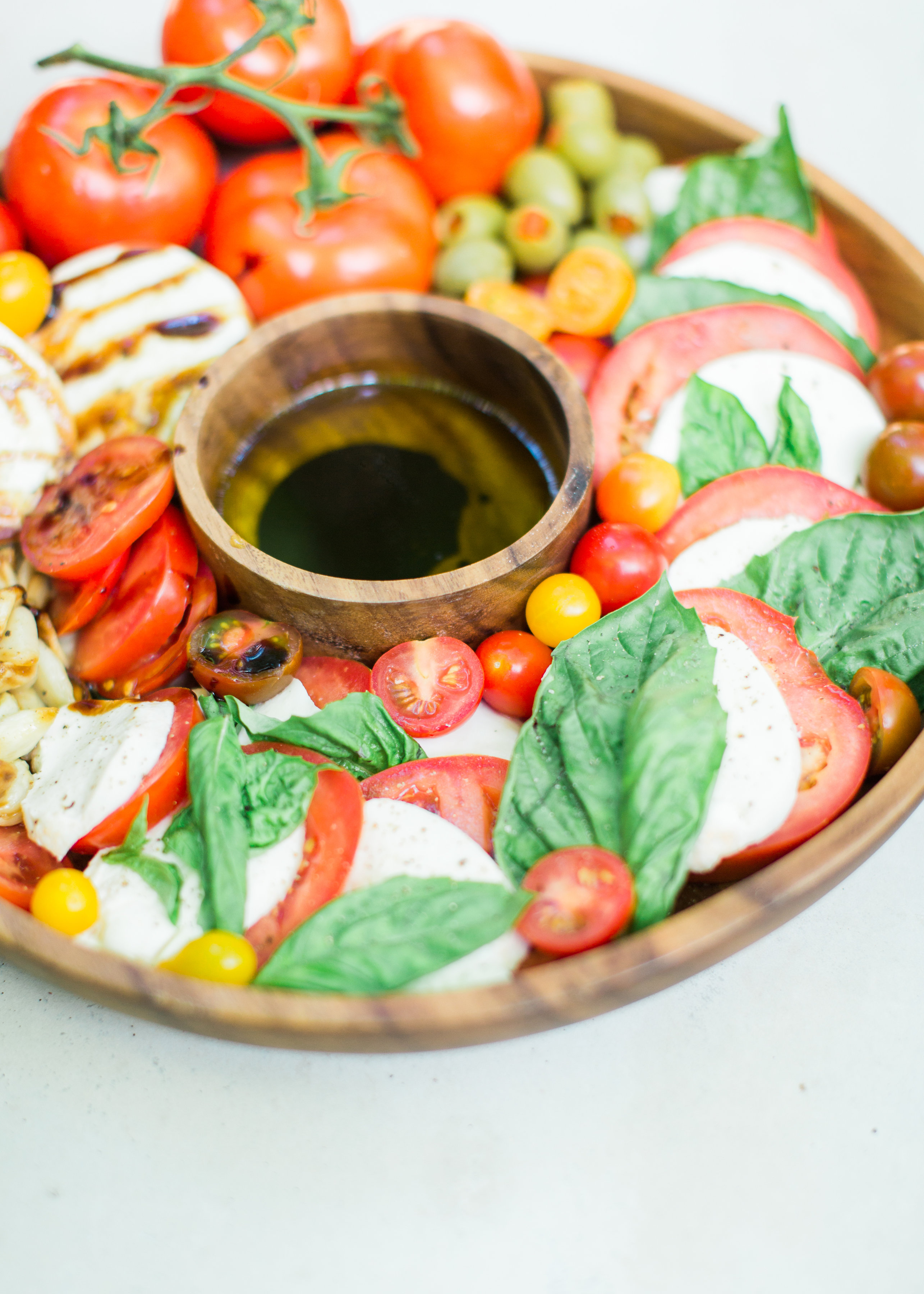 Tomatoes, fresh mozzarella, and basil drizzled with balsamic vinegar, or a sweet balsamic reduction, and olive oil; a caprese salad platter is so easy to make, looks beautiful and impressive (hello, wow factor!), and the magical combination of flavors is totally delicious. Click through for the recipe. #caprese #capresesalad #capresesaladplatter #appetizer #salad #partyfood #recipe #capreserecipe | glitterinc.com | @glitterinc