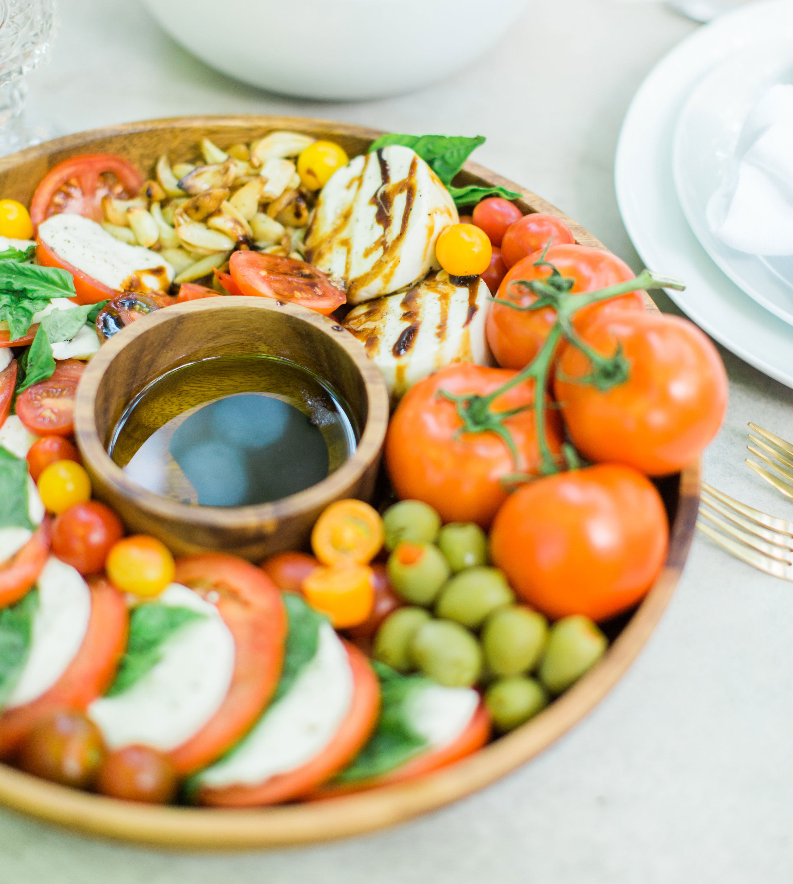 Tomatoes, fresh mozzarella, and basil drizzled with balsamic vinegar, or a sweet balsamic reduction, and olive oil; a caprese salad platter is so easy to make, looks beautiful and impressive (hello, wow factor!), and the magical combination of flavors is totally delicious. Click through for the recipe. #caprese #capresesalad #capresesaladplatter #appetizer #salad #partyfood #recipe #capreserecipe | glitterinc.com | @glitterinc