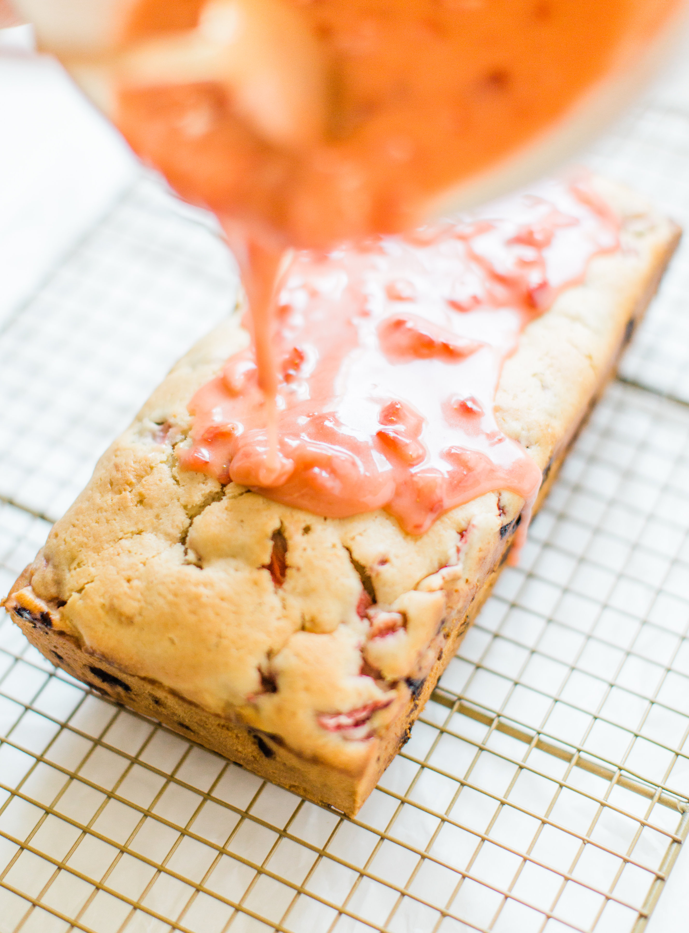 If you love strawberries, you are going to go crazy for this knock-your-socks-off easy and delicious strawberry bread with a decadent strawberry glaze. This quick bread recipe comes together in just 10 minutes, and will impress EVERYONE. #strawberrybread #quickbread #dessert #strawberrycake Click through for the recipe. | glitterinc.com | @glitterinc