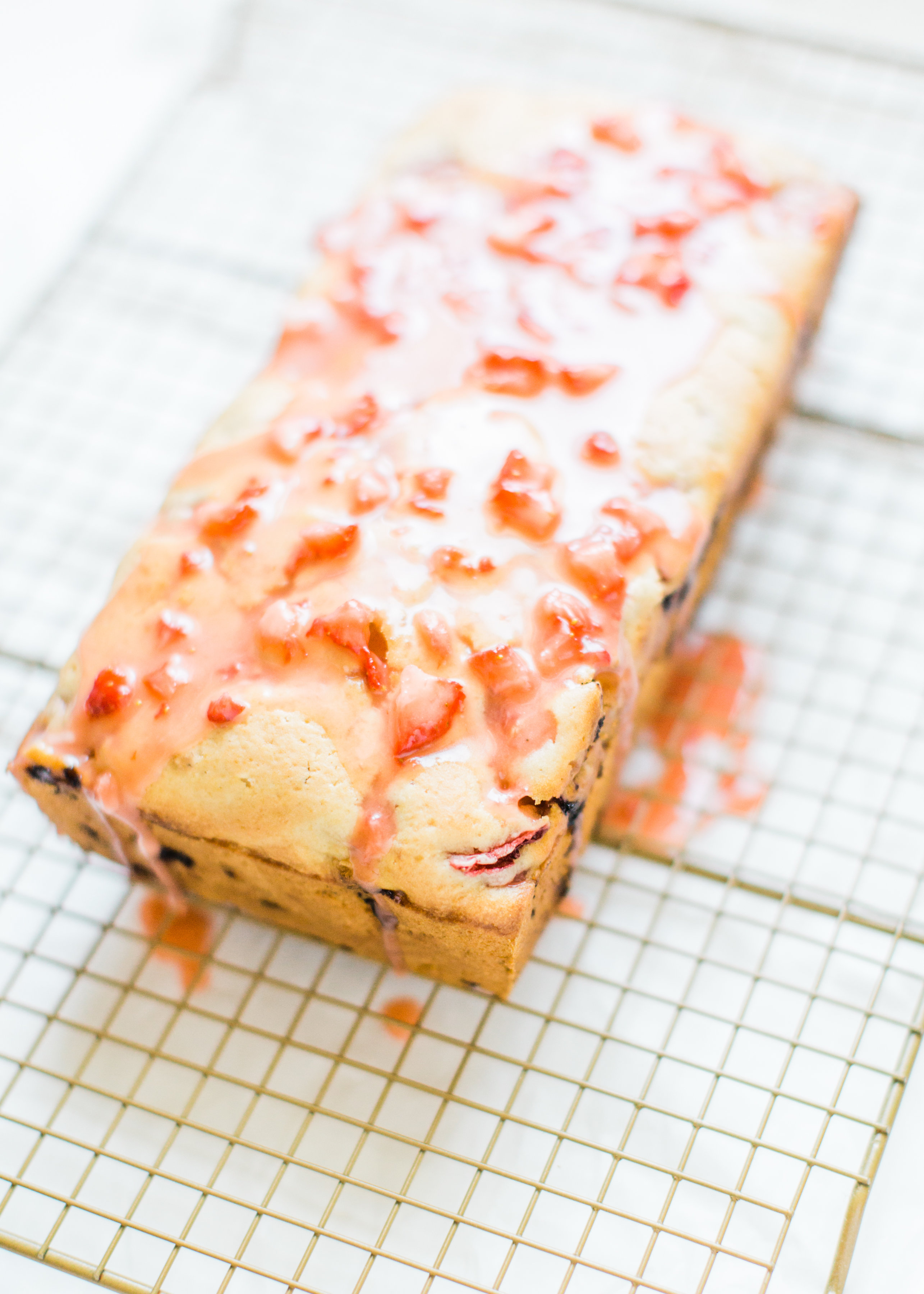 If you love strawberries, you are going to go crazy for this knock-your-socks-off easy and delicious strawberry bread with a decadent strawberry glaze. This quick bread recipe comes together in just 10 minutes, and will impress EVERYONE. #strawberrybread #quickbread #dessert #strawberrycake Click through for the recipe. | glitterinc.com | @glitterinc