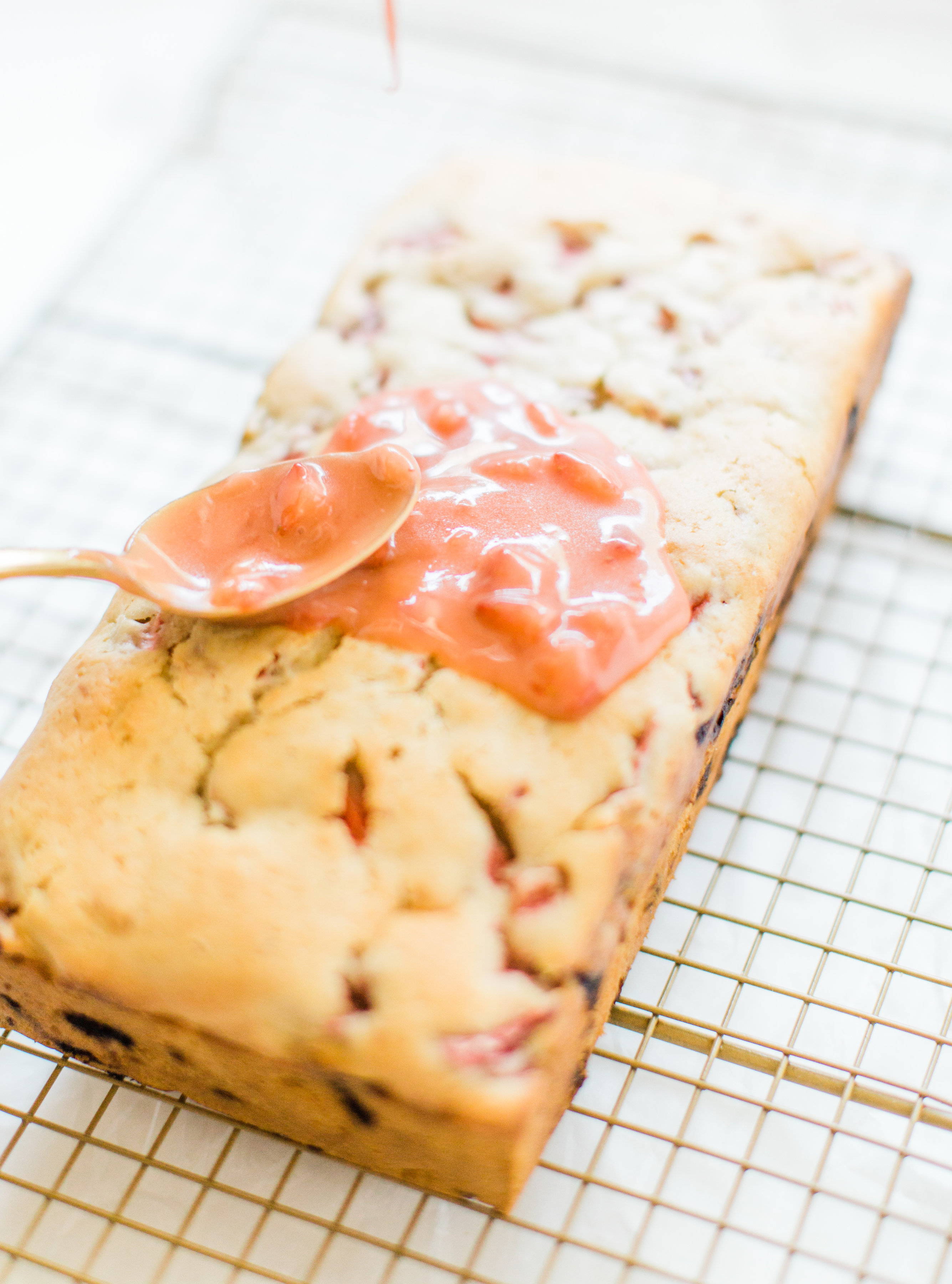 If you love strawberries, you are going to go crazy for this knock-your-socks-off easy and delicious strawberry bread with a decadent strawberry glaze. This quick bread recipe comes together in just 10 minutes, and will impress EVERYONE. #strawberrybread #quickbread #dessert #strawberrycake Click through for the recipe. | glitterinc.com | @glitterinc