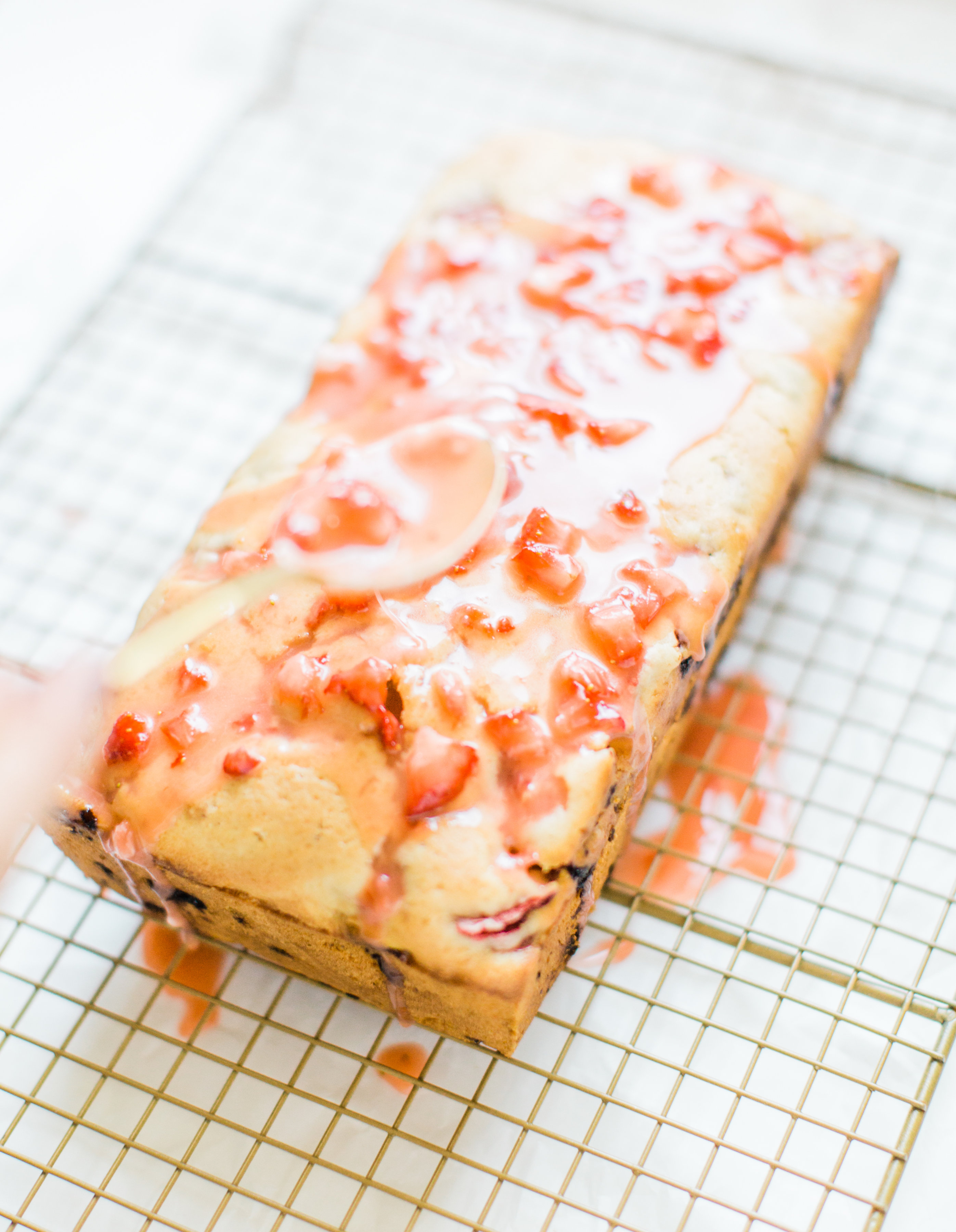 If you love strawberries, you are going to go crazy for this knock-your-socks-off easy and delicious strawberry bread with a decadent strawberry glaze. This quick bread recipe comes together in just 10 minutes, and will impress EVERYONE. #strawberrybread #quickbread #dessert #strawberrycake Click through for the recipe. | glitterinc.com | @glitterinc