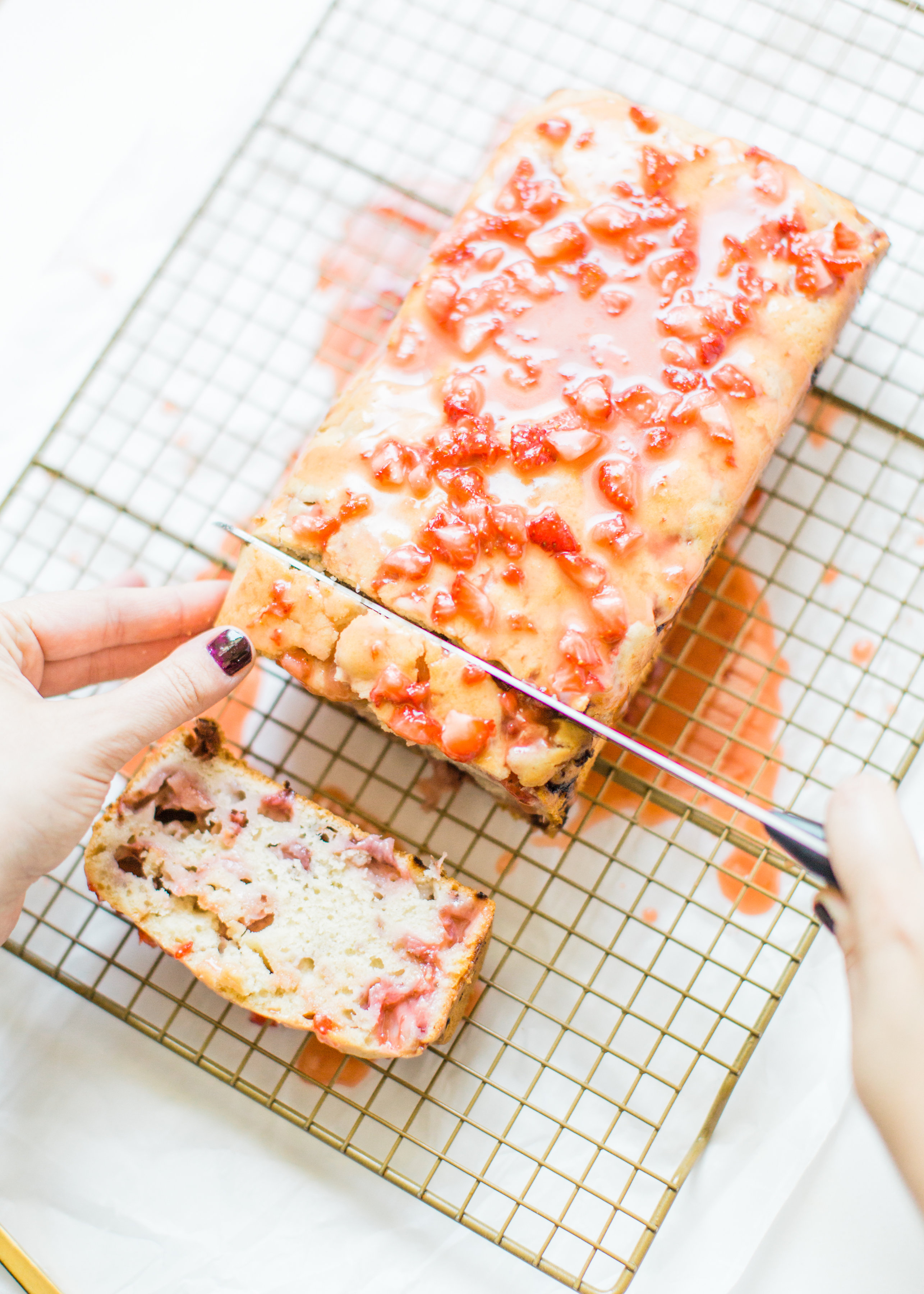 If you love strawberries, you are going to go crazy for this knock-your-socks-off easy and delicious strawberry bread with a decadent strawberry glaze. This quick bread recipe comes together in just 10 minutes, and will impress EVERYONE. #strawberrybread #quickbread #dessert #strawberrycake Click through for the recipe. | glitterinc.com 