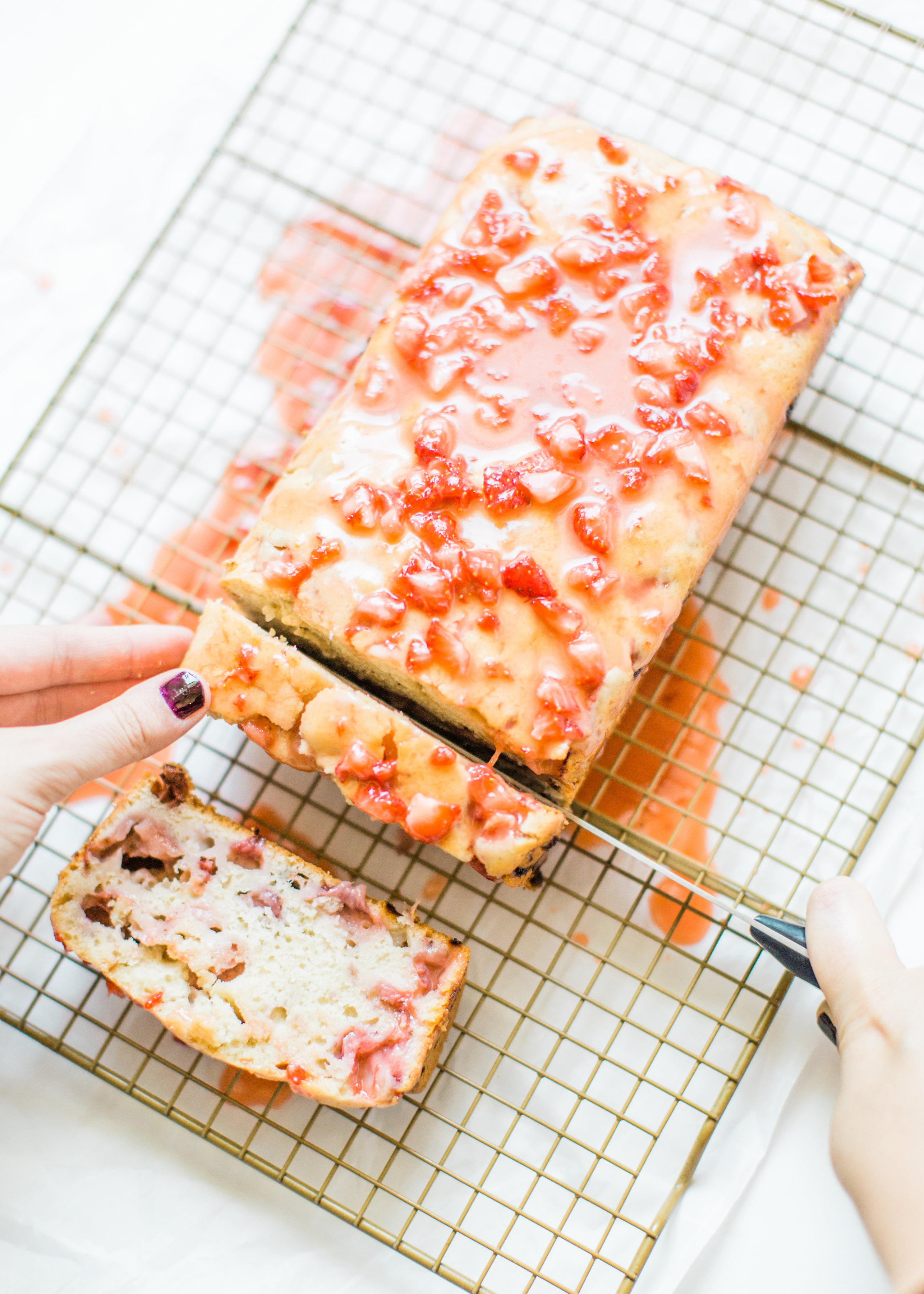 If you love strawberries, you are going to go crazy for this knock-your-socks-off easy and delicious strawberry bread with a decadent strawberry glaze. This quick bread recipe comes together in just 10 minutes, and will impress EVERYONE. #strawberrybread #quickbread #dessert #strawberrycake Click through for the recipe. | glitterinc.com | @glitterinc