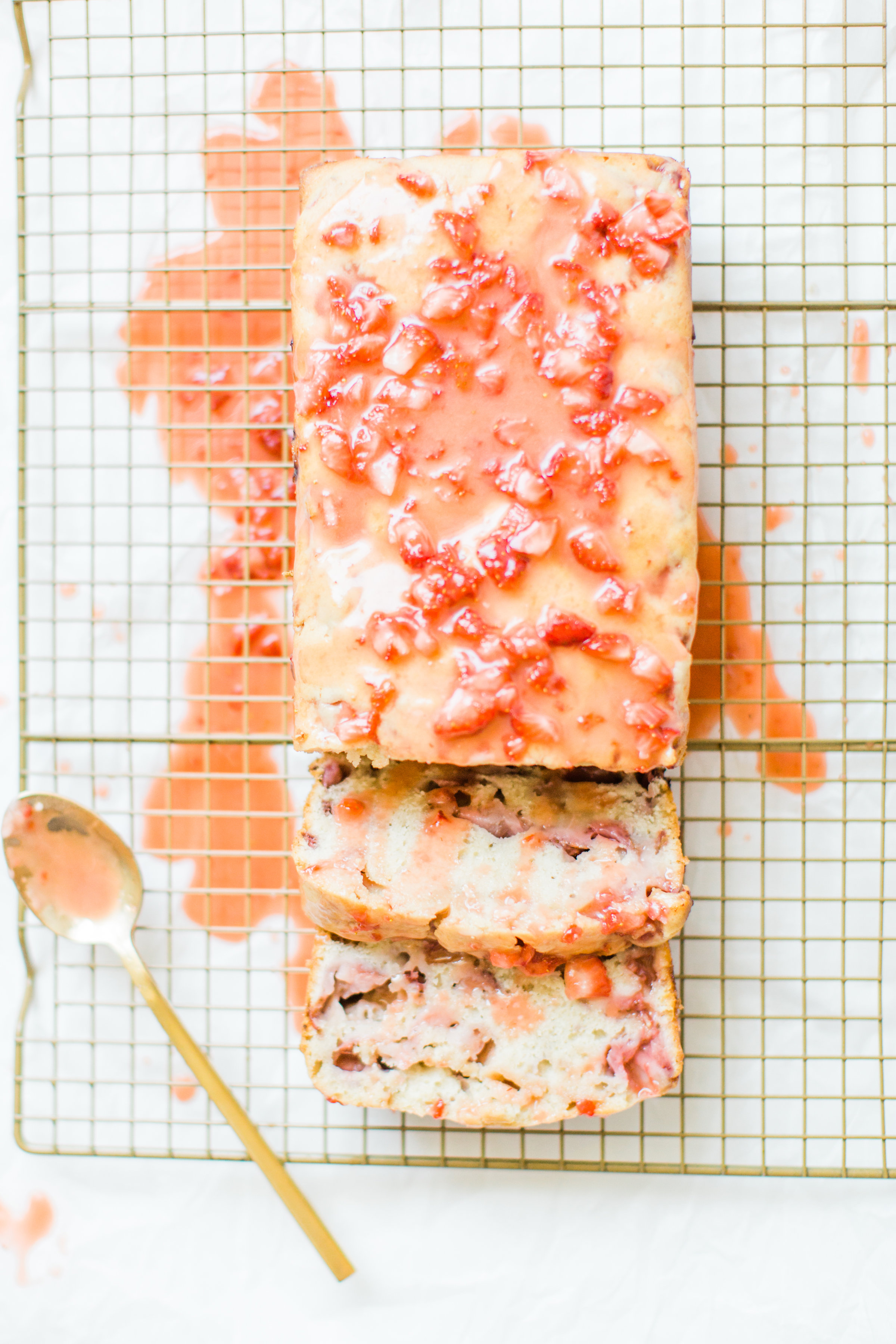 If you love strawberries, you are going to go crazy for this knock-your-socks-off easy and delicious strawberry bread with a decadent strawberry glaze. This quick bread recipe comes together in just 10 minutes, and will impress EVERYONE. #strawberrybread #quickbread #dessert #strawberrycake Click through for the recipe. | glitterinc.com | @glitterinc