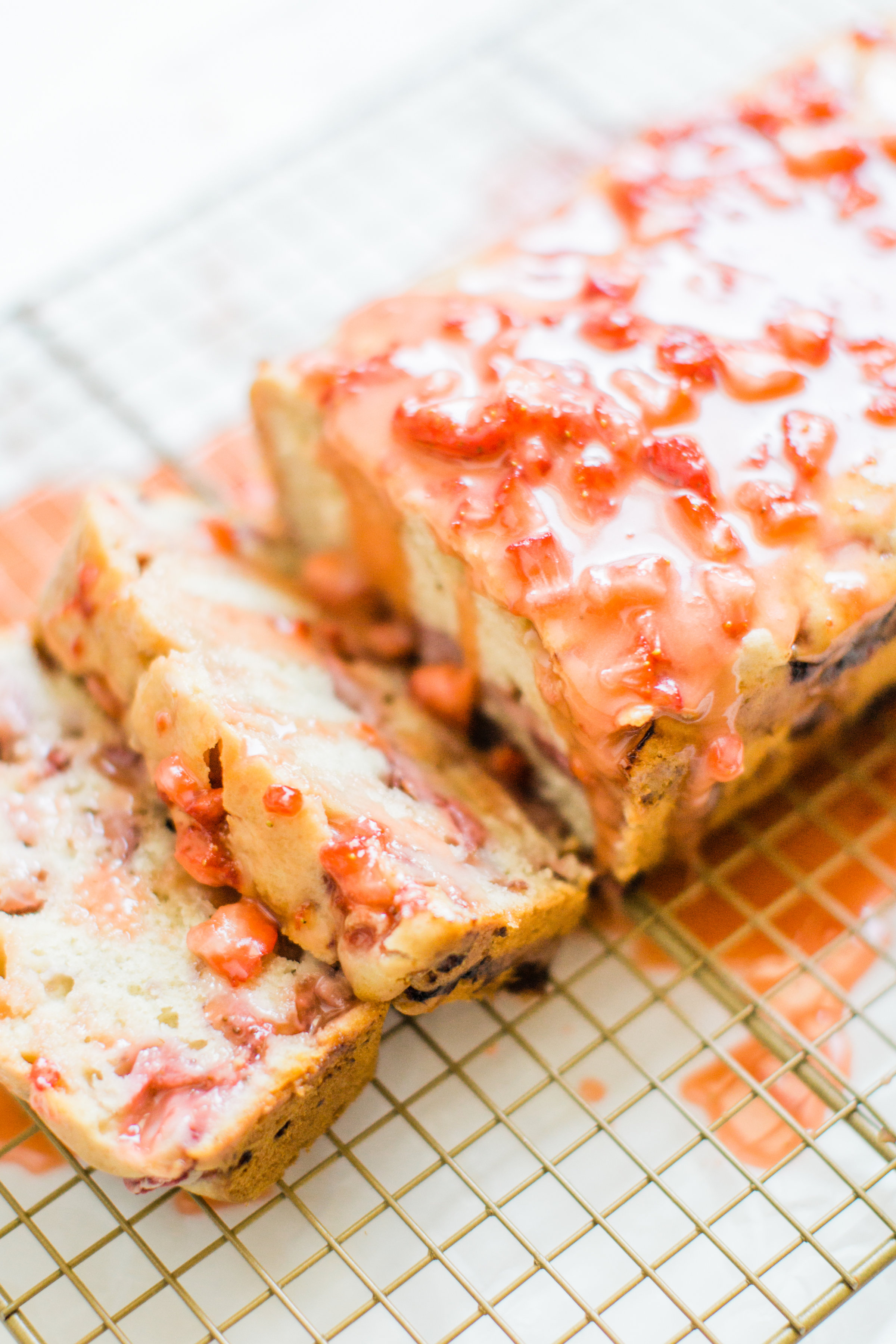 If you love strawberries, you are going to go crazy for this knock-your-socks-off easy and delicious strawberry bread with a decadent strawberry glaze. This quick bread recipe comes together in just 10 minutes, and will impress EVERYONE. #strawberrybread #quickbread #dessert #strawberrycake Click through for the recipe. | glitterinc.com | @glitterinc