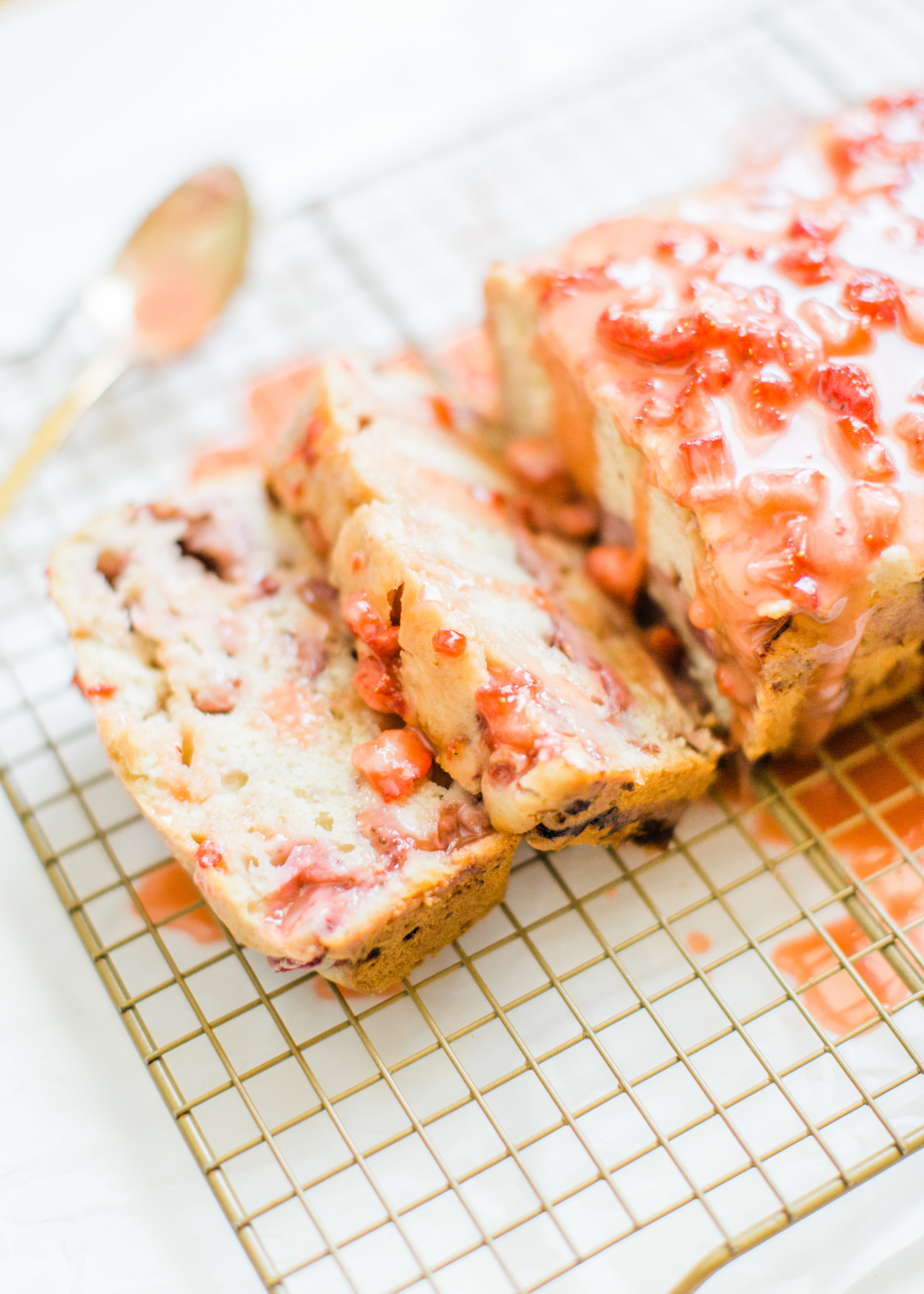 If you love strawberries, you are going to go crazy for this knock-your-socks-off easy and delicious strawberry bread with a decadent strawberry glaze. This quick bread recipe comes together in just 10 minutes, and will impress EVERYONE. #strawberrybread #quickbread #dessert #strawberrycake Click through for the recipe. | glitterinc.com | @glitterinc