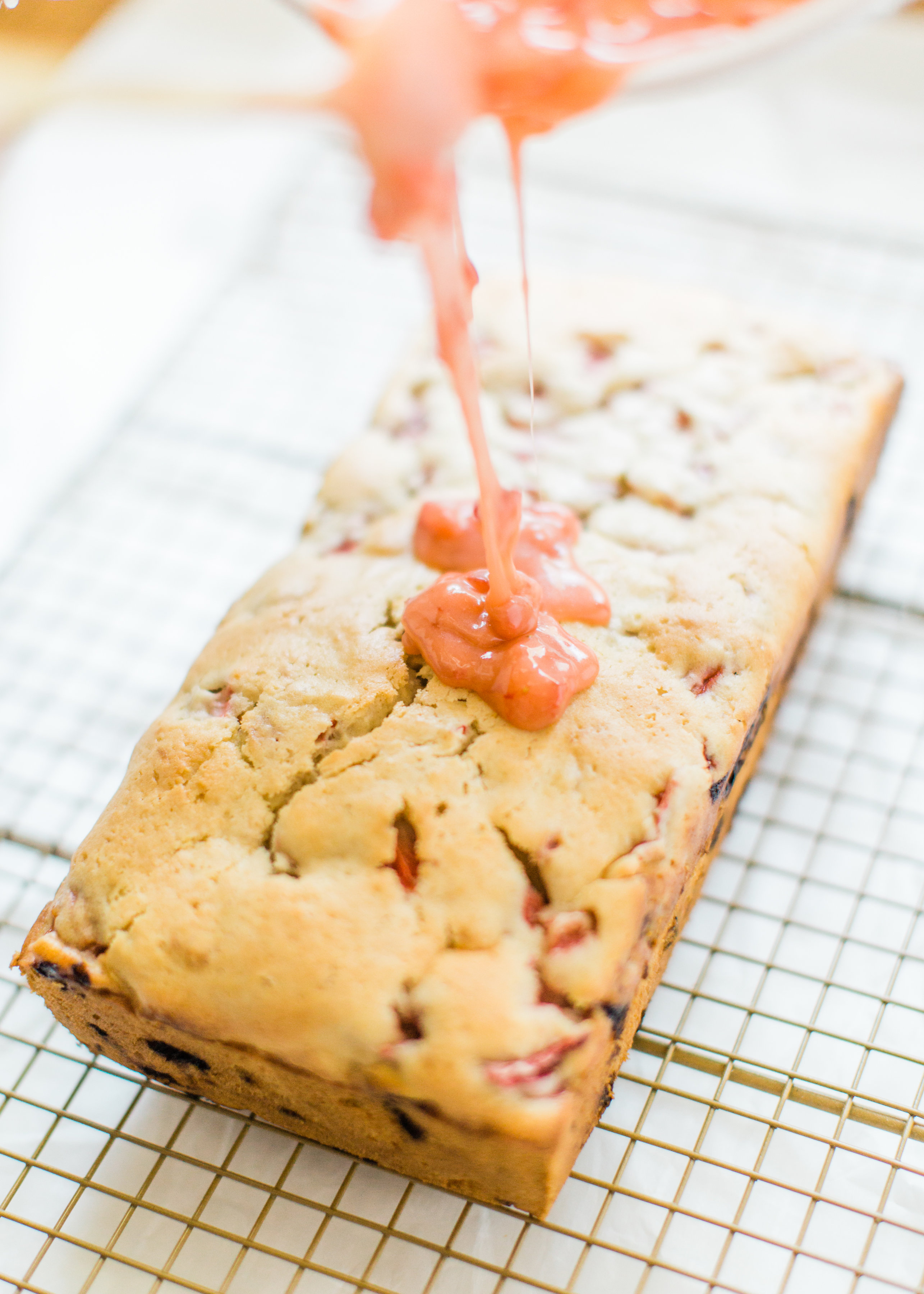 If you love strawberries, you are going to go crazy for this knock-your-socks-off easy and delicious strawberry bread with a decadent strawberry glaze. This quick bread recipe comes together in just 10 minutes, and will impress EVERYONE. #strawberrybread #quickbread #dessert #strawberrycake Click through for the recipe. | glitterinc.com | @glitterinc