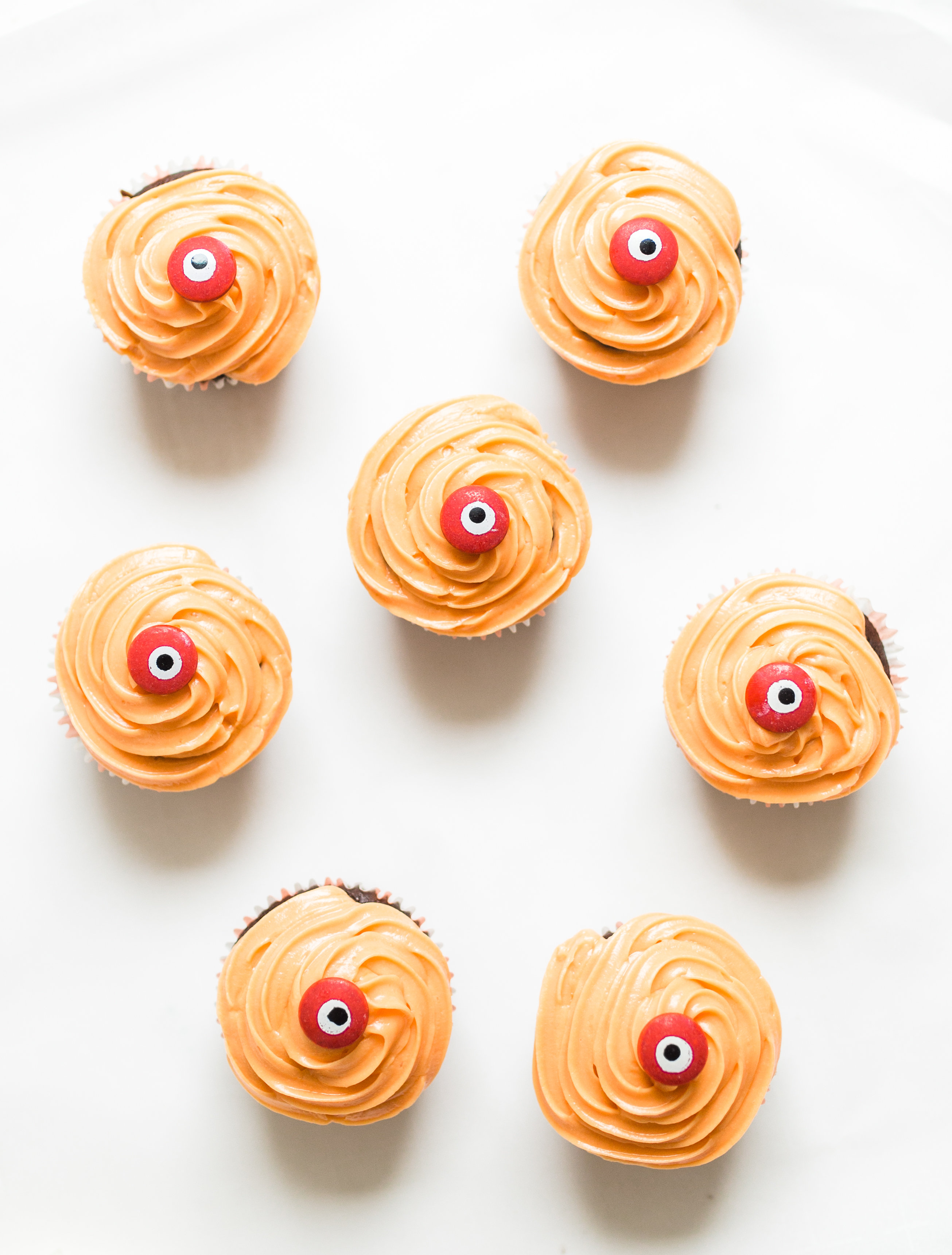 Make these absolutely adorable haunted Halloween eyeball chocolate cupcakes with our favorite easy crazy cake recipe. These easy-to-make cupcakes are perfect for your next spooky Halloween party! Click through for the #recipe. #halloween #halloweencupcakes #crazycake #crazycakecupcakes #halloweendessert #halloweendiy #diy #eyeballcupcakes #spookycupcakes #halloweencake | glitterinc.com | @glitterinc