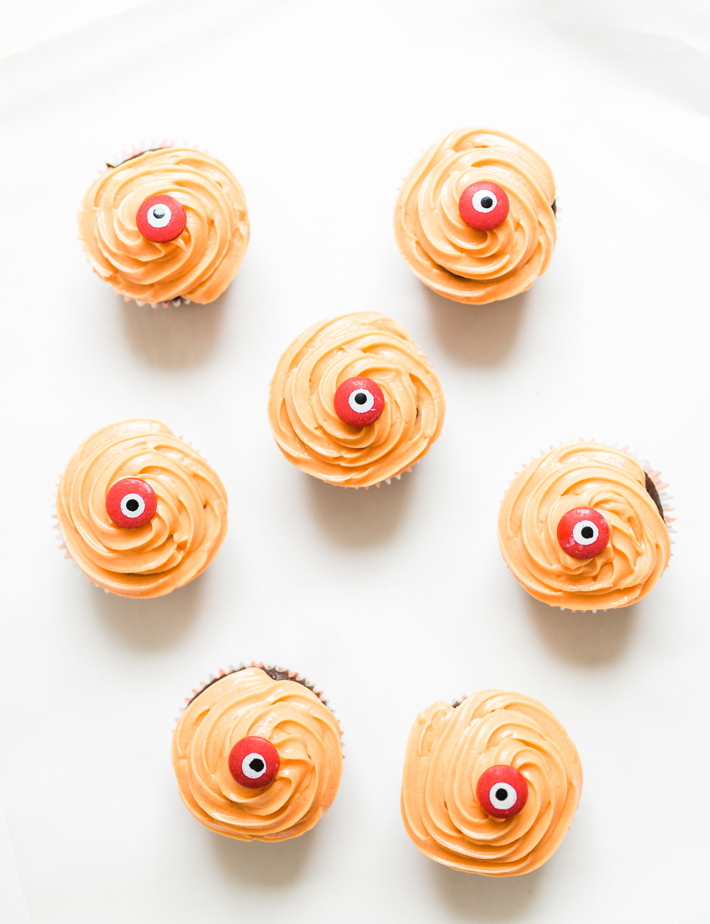 Make these absolutely adorable haunted Halloween eyeball chocolate cupcakes with our favorite easy crazy cake recipe. These easy-to-make cupcakes are perfect for your next spooky Halloween party! Click through for the #recipe. #halloween #halloweencupcakes #crazycake #crazycakecupcakes #halloweendessert #halloweendiy #diy #eyeballcupcakes #spookycupcakes #halloweencake | glitterinc.com | @glitterinc