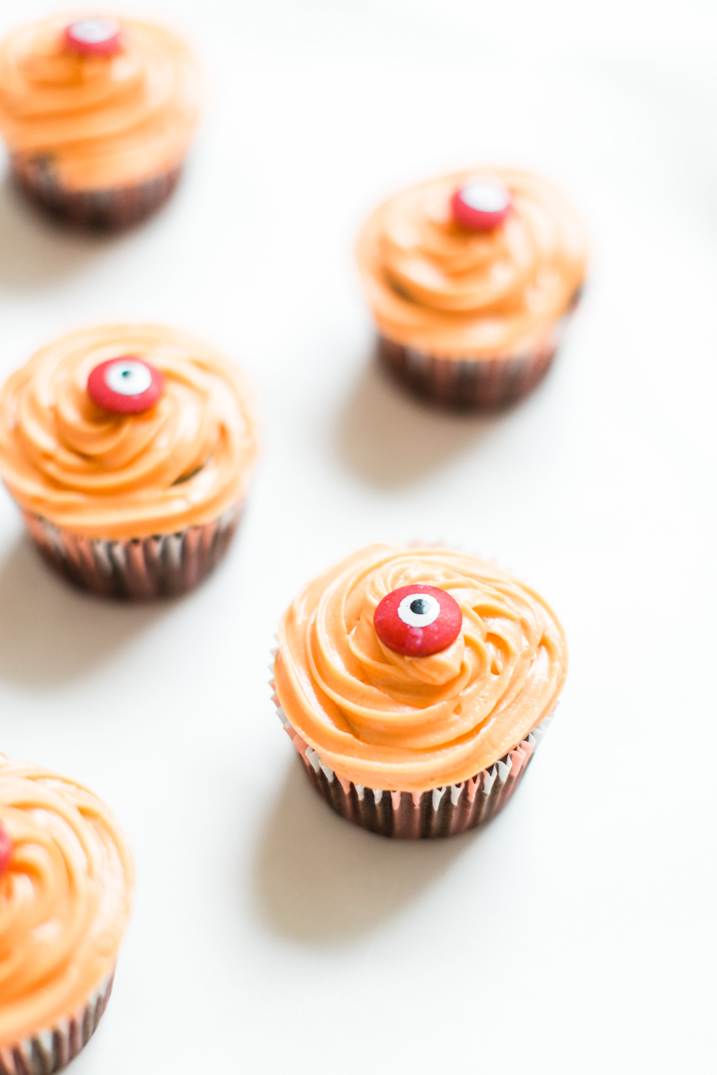 Make these absolutely adorable haunted Halloween eyeball chocolate cupcakes with our favorite easy crazy cake recipe. These easy-to-make cupcakes are perfect for your next spooky Halloween party! Click through for the #recipe. #halloween #halloweencupcakes #crazycake #crazycakecupcakes #halloweendessert #halloweendiy #diy #eyeballcupcakes #spookycupcakes #halloweencake | glitterinc.com | @glitterinc