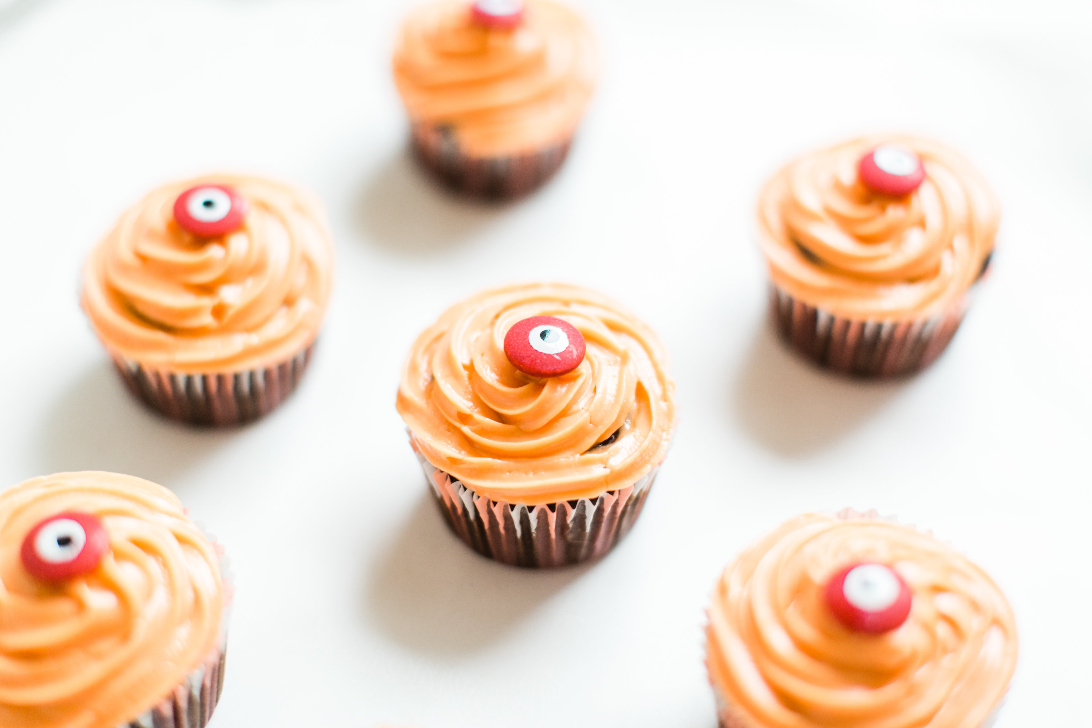 Make these absolutely adorable haunted Halloween eyeball chocolate cupcakes with our favorite easy crazy cake recipe. These easy-to-make cupcakes are perfect for your next spooky Halloween party! Click through for the #recipe. #halloween #halloweencupcakes #crazycake #crazycakecupcakes #halloweendessert  #diy #eyeballcupcakes #spookycupcakes #halloweencake | glitterinc.com | @glitterinc