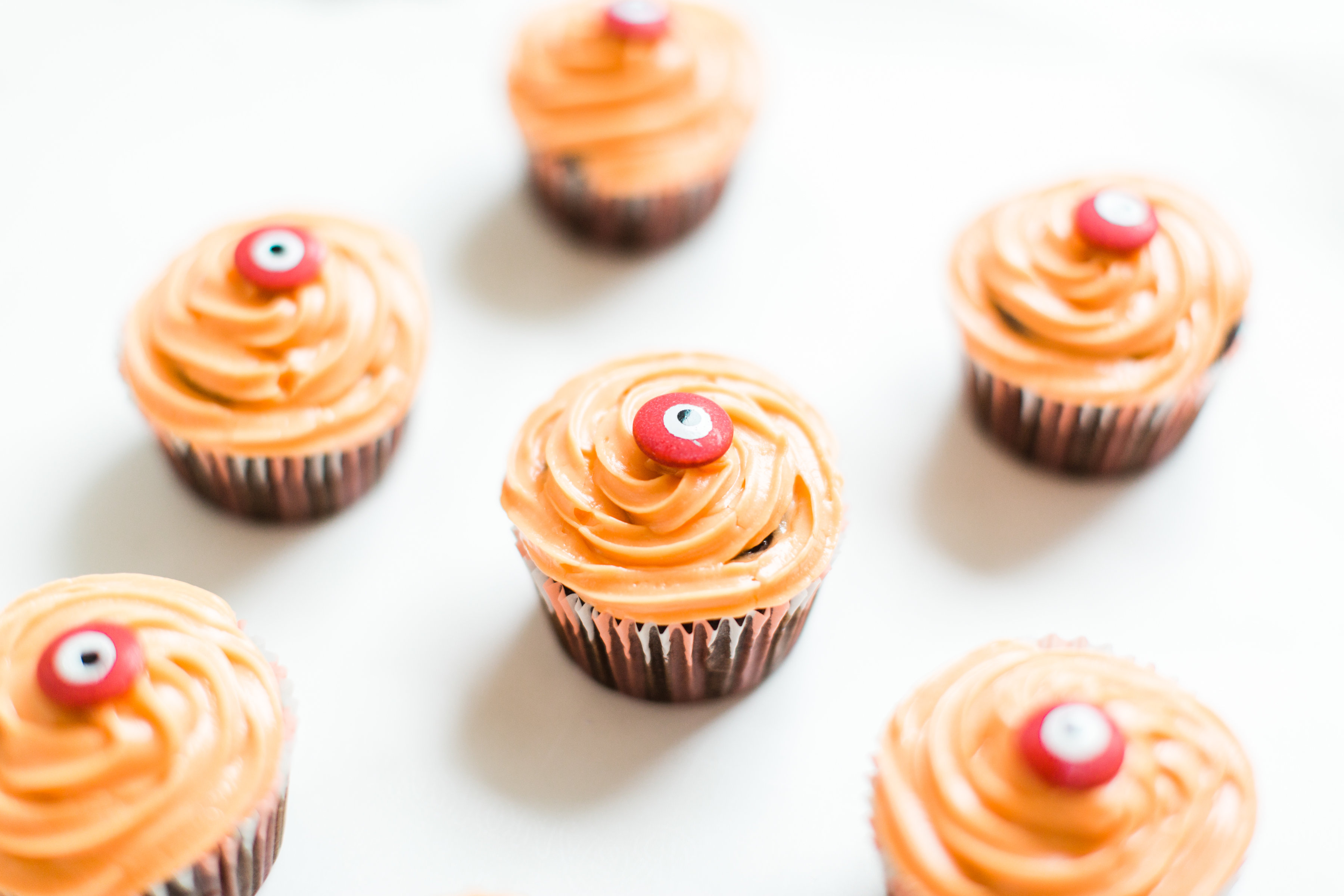 Make these absolutely adorable haunted Halloween eyeball chocolate cupcakes with our favorite easy crazy cake recipe. These easy-to-make cupcakes are perfect for your next spooky Halloween party! Click through for the #recipe. #halloween #halloweencupcakes #crazycake #crazycakecupcakes #halloweendessert #halloweendiy #diy #eyeballcupcakes #spookycupcakes #halloweencake | glitterinc.com | @glitterinc