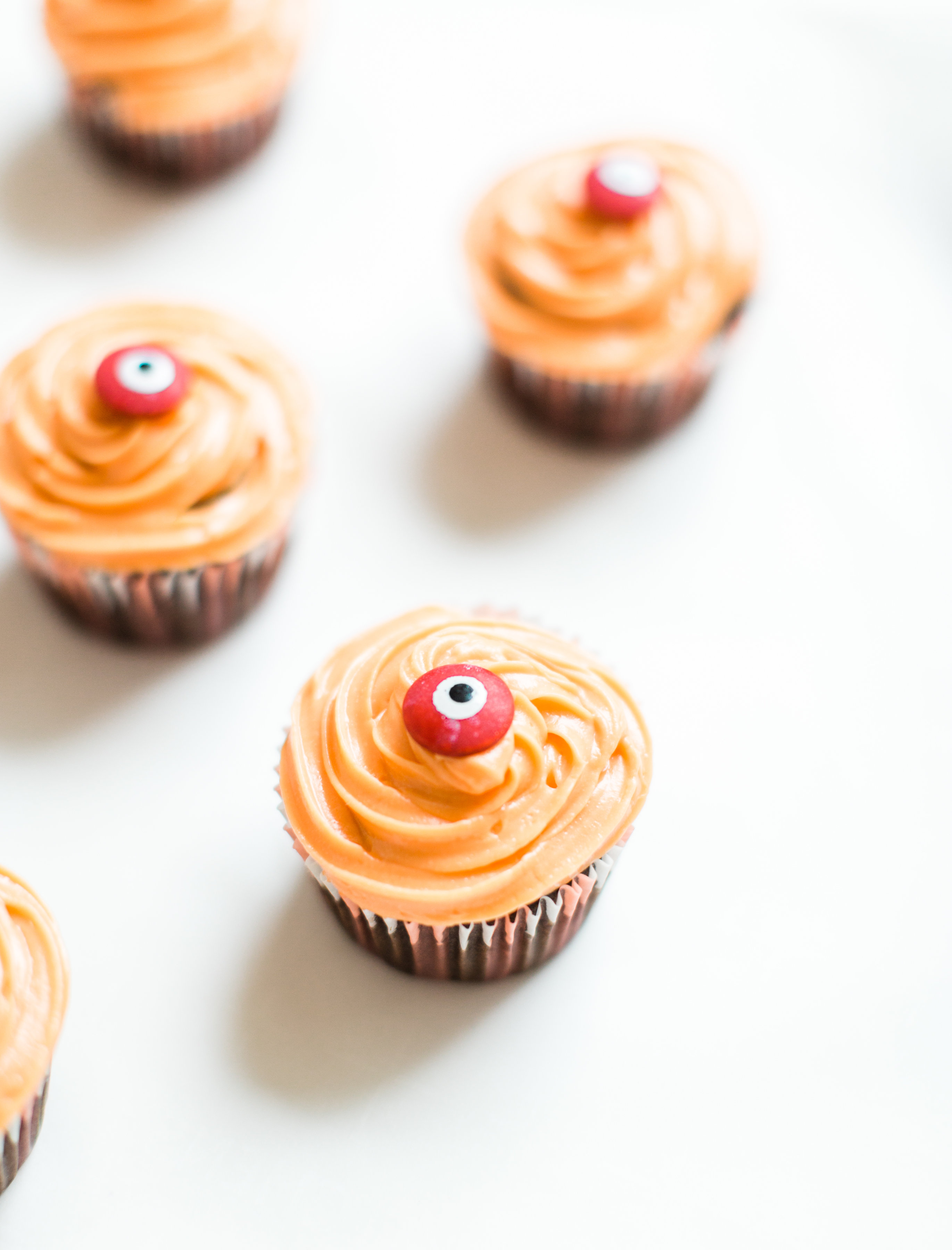 Make these absolutely adorable haunted Halloween eyeball chocolate cupcakes with our favorite easy crazy cake recipe. These easy-to-make cupcakes are perfect for your next spooky Halloween party! Click through for the #recipe. #halloween #halloweencupcakes #crazycake #crazycakecupcakes #halloweendessert #halloweendiy #diy #eyeballcupcakes #spookycupcakes #halloweencake | glitterinc.com | @glitterinc