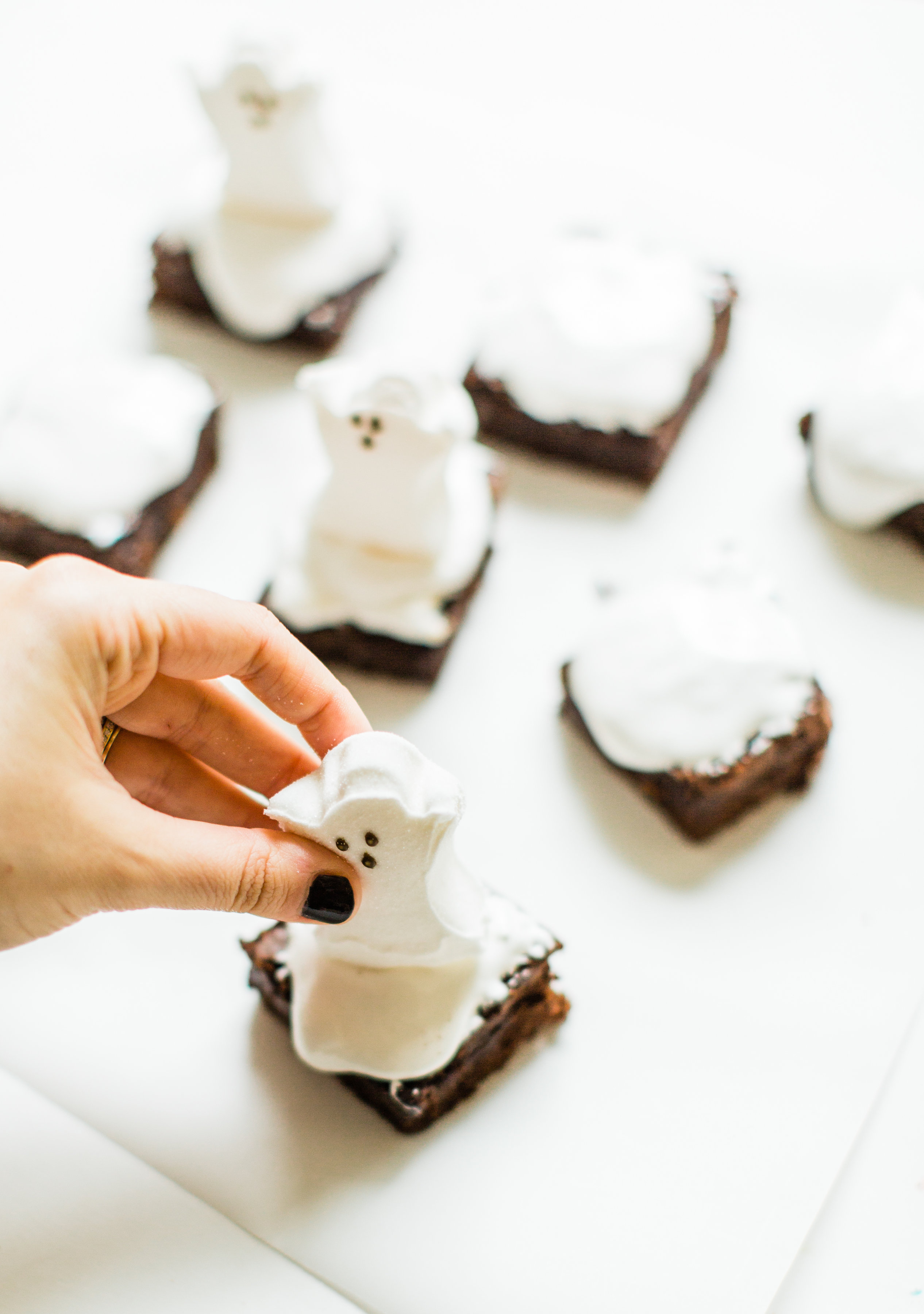 These spooky Halloween ghost brownies are delicious, adorable, and so easy to make. Kids and grownups alike will clamor for these haunted brownies! Click through for the details. #ghostbrownies #halloween #halloweendessert #halloweenbrownies #recipe #halloweenrecipe #diy #diyghostbrownies #halloweendesserts | glitterinc.com | @glitterinc