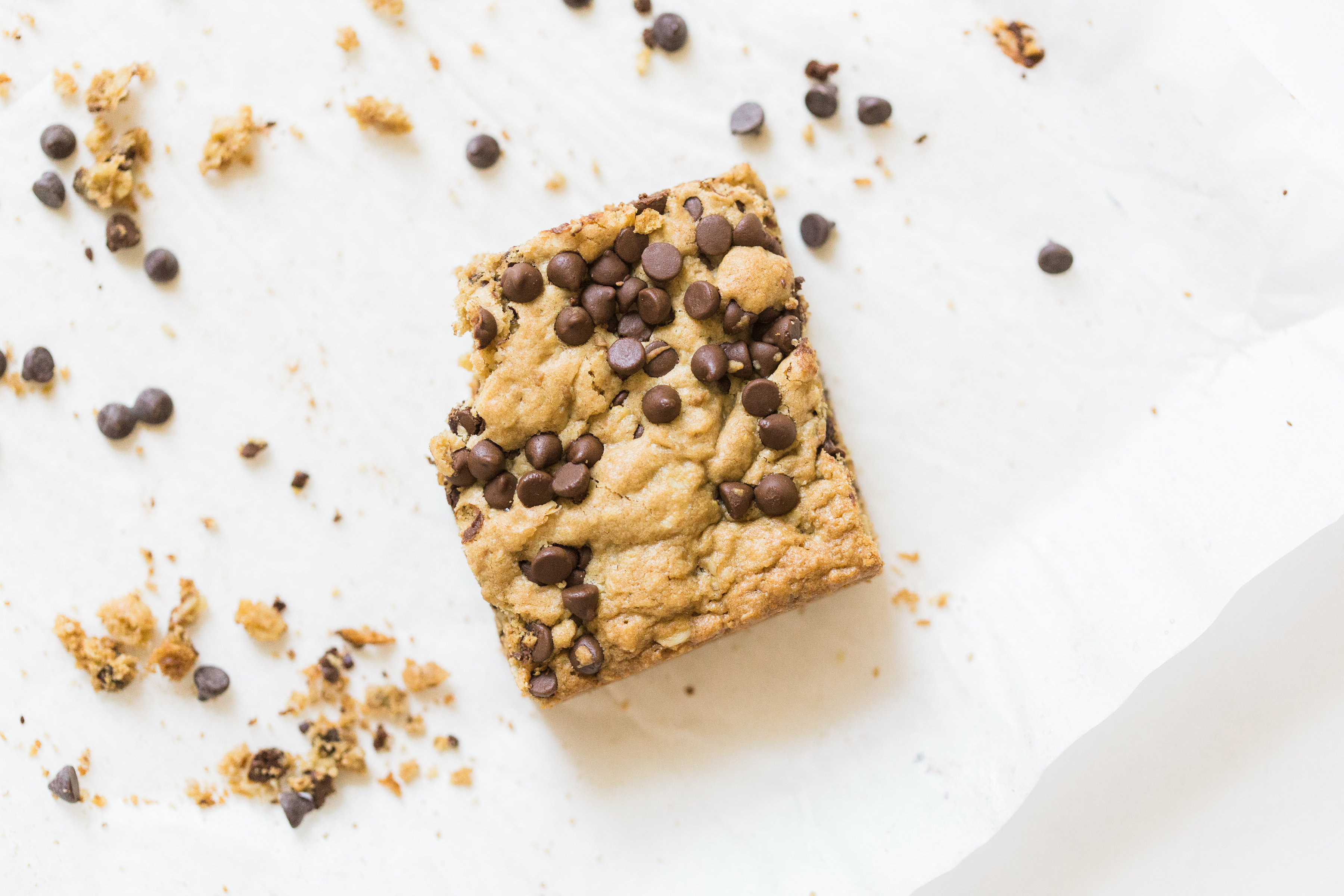 Delicious chocolate chip oatmeal cookies made extra simple by baking them up in a big batch of bars, these super moist chocolate chip oatmeal cookie bars are a favorite of our whole family, and for good reason! Click through for the #recipe. #oatmealcookies #oatmealcookiebars #cookiebars #cookierecipe #oatmealcookierecipe #dairyfree | glitterinc.com | @glitterinc