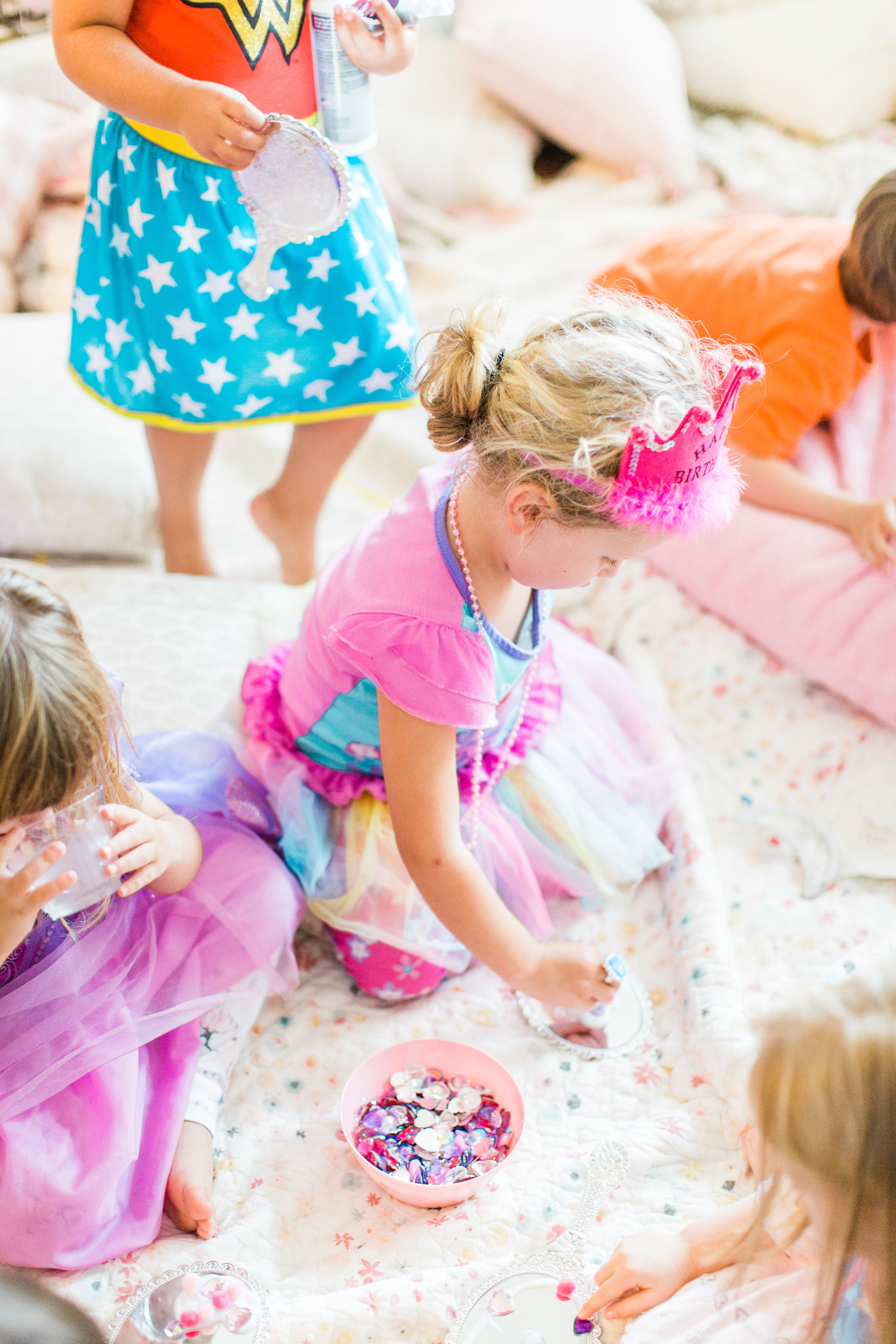 Ready to throw one beautiful and memorable princess pajama birthday party? Have we got some inspiration for you! We turned our living room into one giant slumber party and covered every available space with sheets, pillows, and blankets, plus gorgeous pink florals, a cozy tent lounge, a DIY magic mirror decorating activity for the kids, a dress-up station with crowns, wands, and wings, a pin the tail on the unicorn game, and so much more. Click through for the party details. #party #pajamaparty #princessparty #dressup | glitterinc.com | @glitterinc