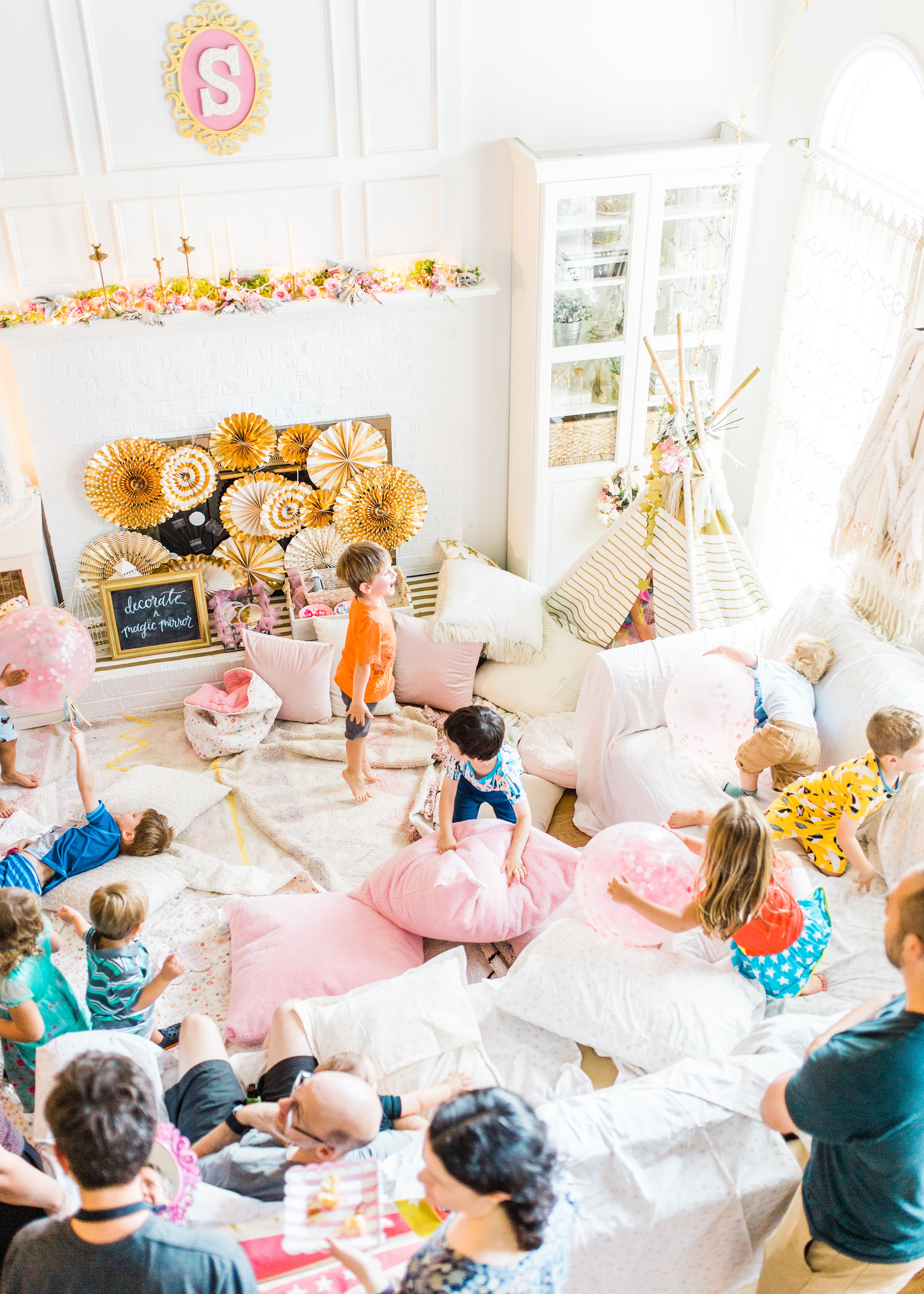 Ready to throw one beautiful and memorable princess pajama birthday party? Have we got some inspiration for you! We turned our living room into one giant slumber party and covered every available space with sheets, pillows, and blankets, plus gorgeous pink florals, a cozy tent lounge, a DIY magic mirror decorating activity for the kids, a dress-up station with crowns, wands, and wings, a pin the tail on the unicorn game, and so much more. Click through for the party details. #party #pajamaparty #princessparty #dressup | glitterinc.com | @glitterinc