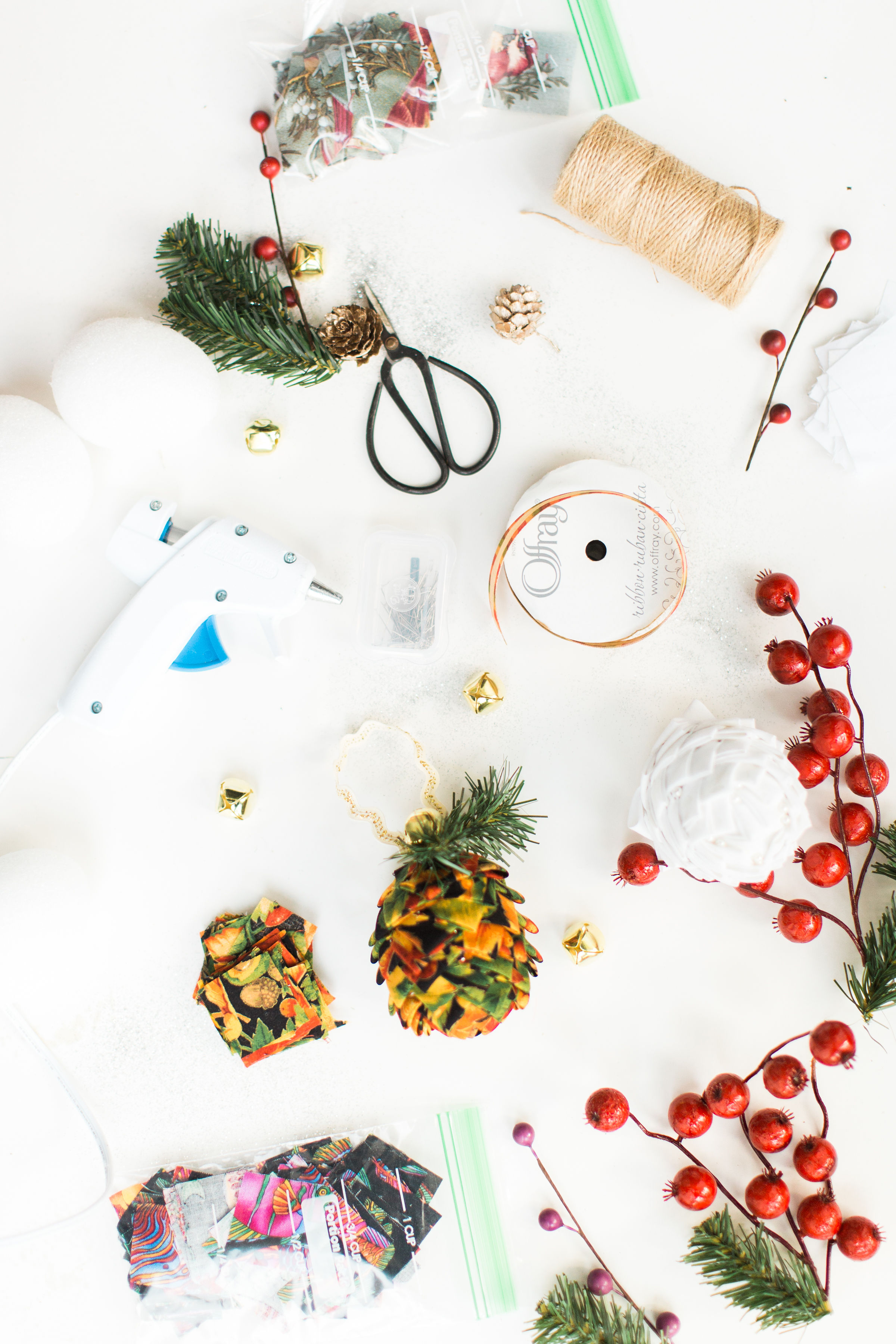 Looking for a fun Christmas craft to make this holiday season? DIY folded fabric pinecones make the prettiest ornaments, are perfect as gift toppers, and use up leftover fabric scraps - no sewing required. Click through for the details.  #christmascraft #holidaycraft #holidaydiy #christmasdiy #nosew | glitterinc.com | @glitterinc