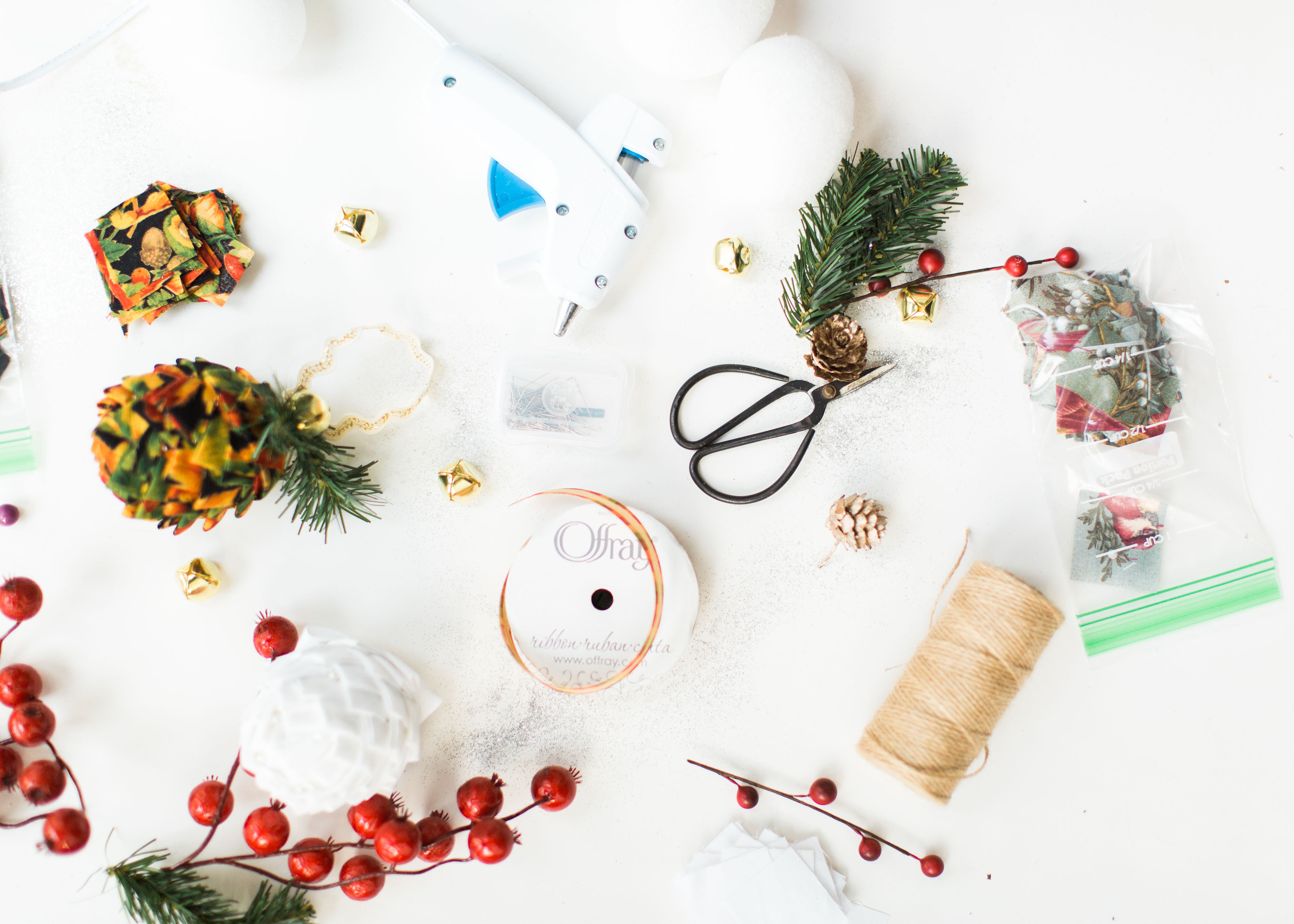 Looking for a fun Christmas craft to make this holiday season? DIY folded fabric pinecones make the prettiest ornaments, are perfect as gift toppers, and use up leftover fabric scraps - no sewing required. Click through for the details. #diyfabricpinecones #christmascraft #holidaycraft #holidaydiy #christmasdiy #nosew | glitterinc.com | @glitterinc